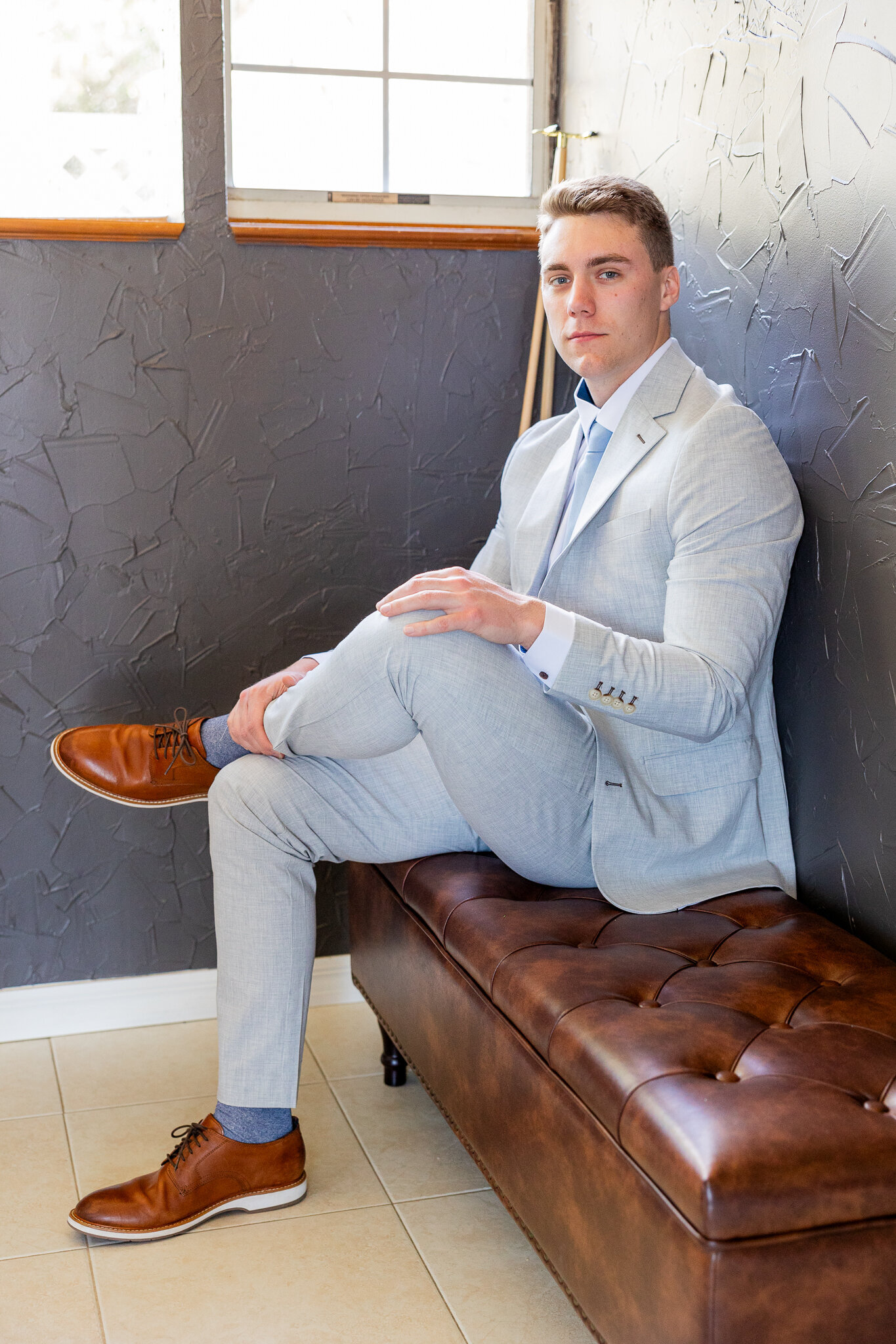groom sitting in the getting ready suite