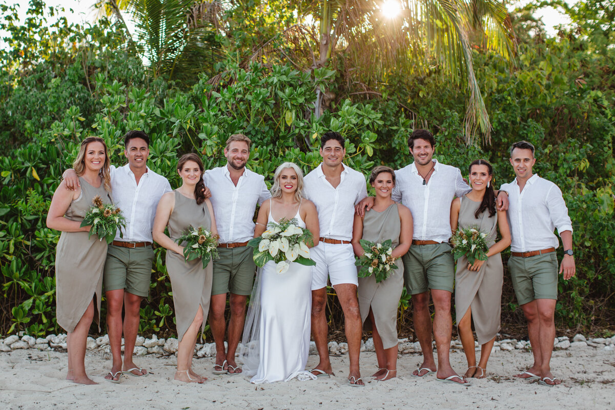 Bridal party looking at camera on beach