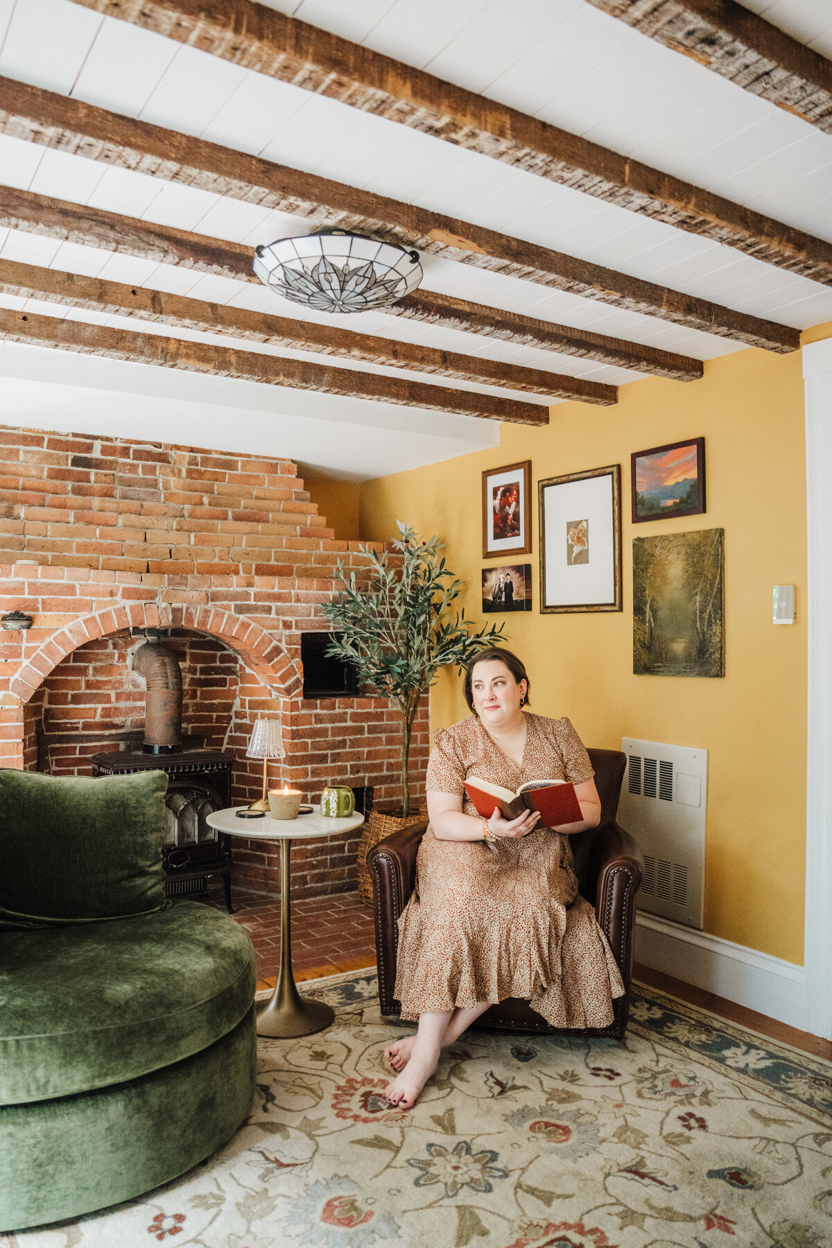 woman sits in antique sitting room with yellow wall
