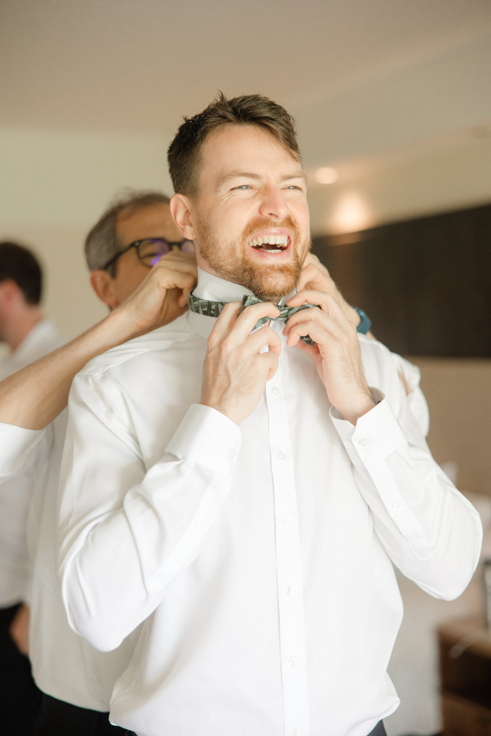 Groom adjusting bow tie