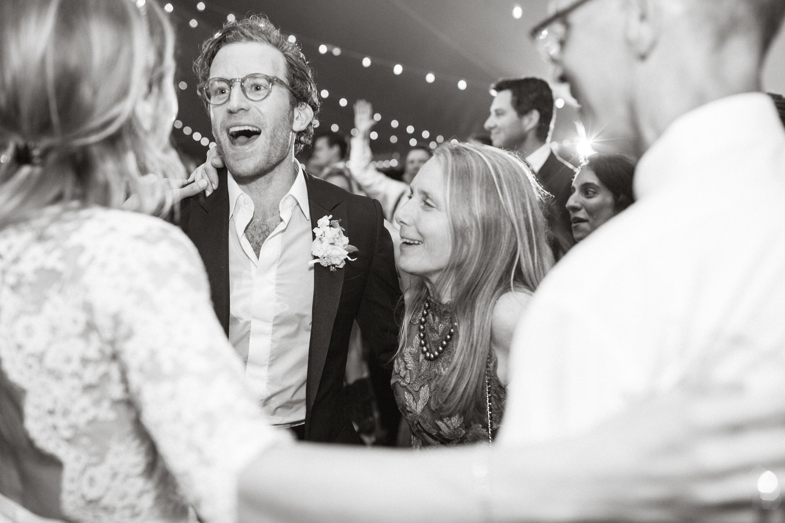Candid shot of the bride and her parents with the groom on the dance floor!