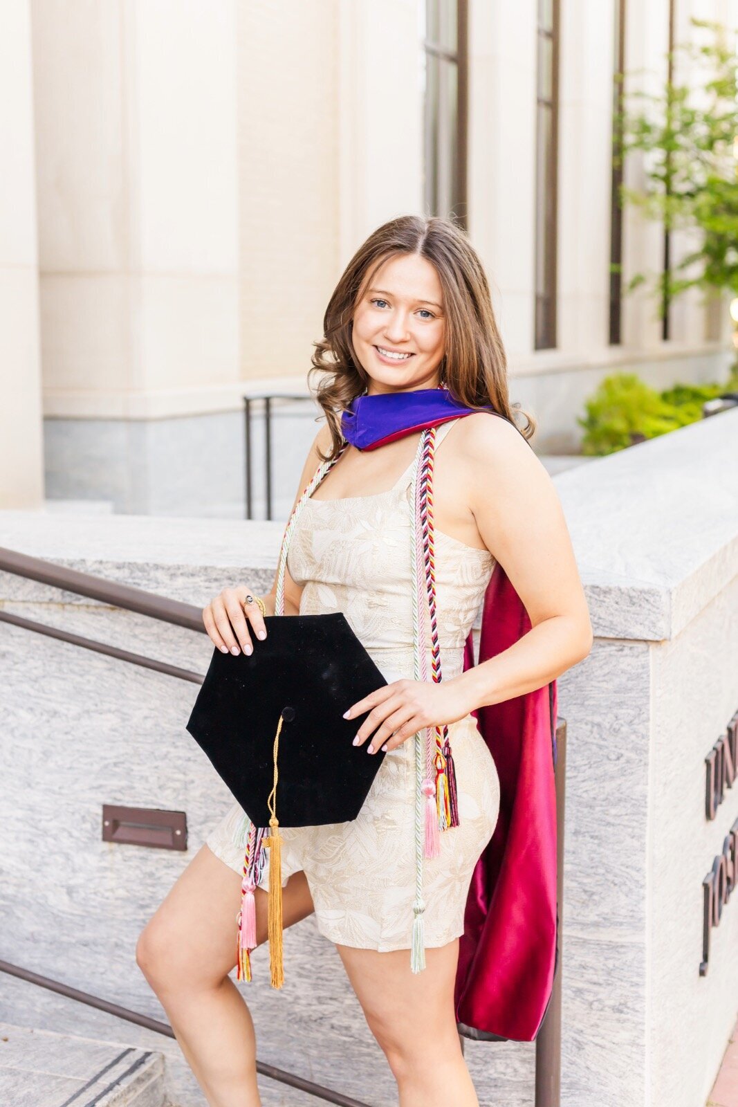 Girl holding graduation cap and smiling