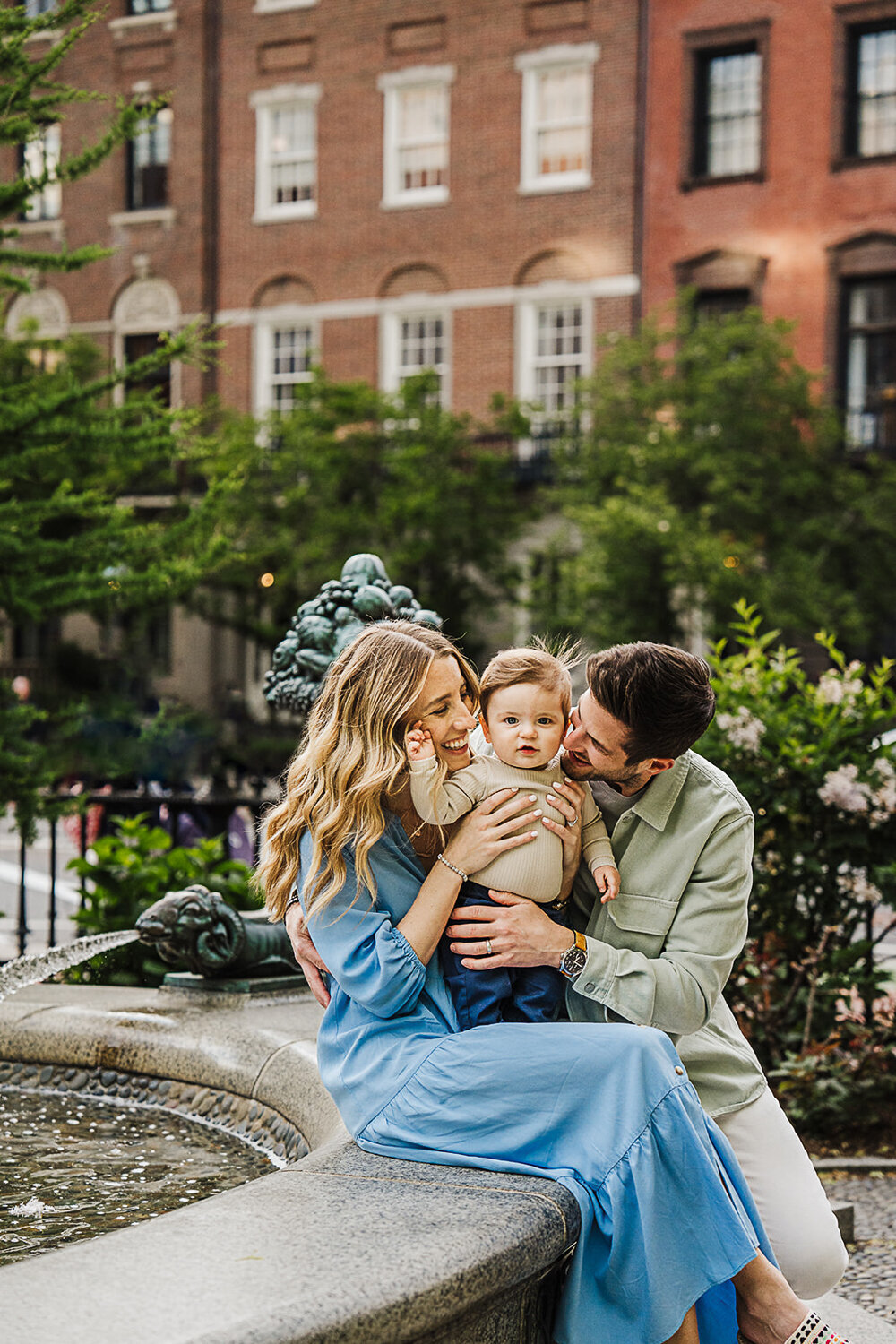 family of three take photos in boston public garden