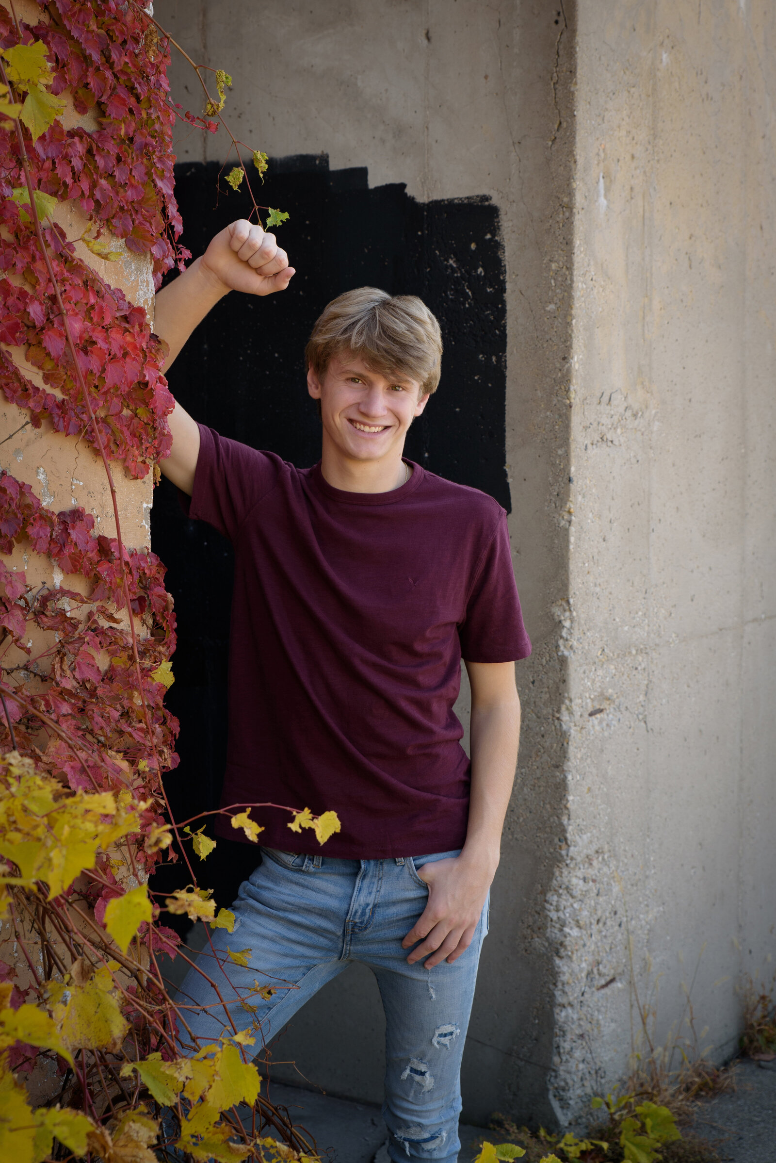 Senior boy standing in doorway in urban setting in Green Bay, Wisconsin