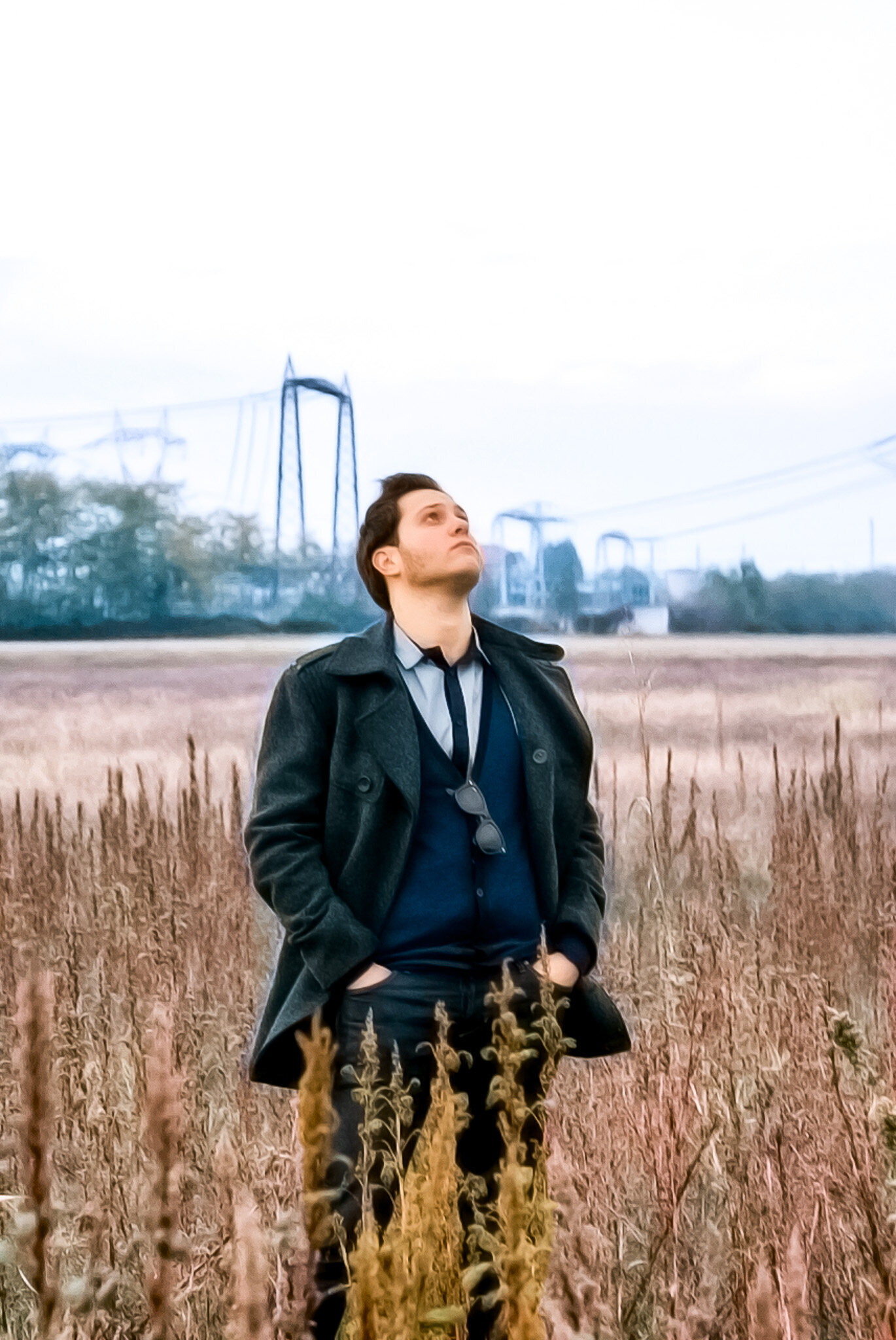 Young Man looking at the sky in a field in a suit