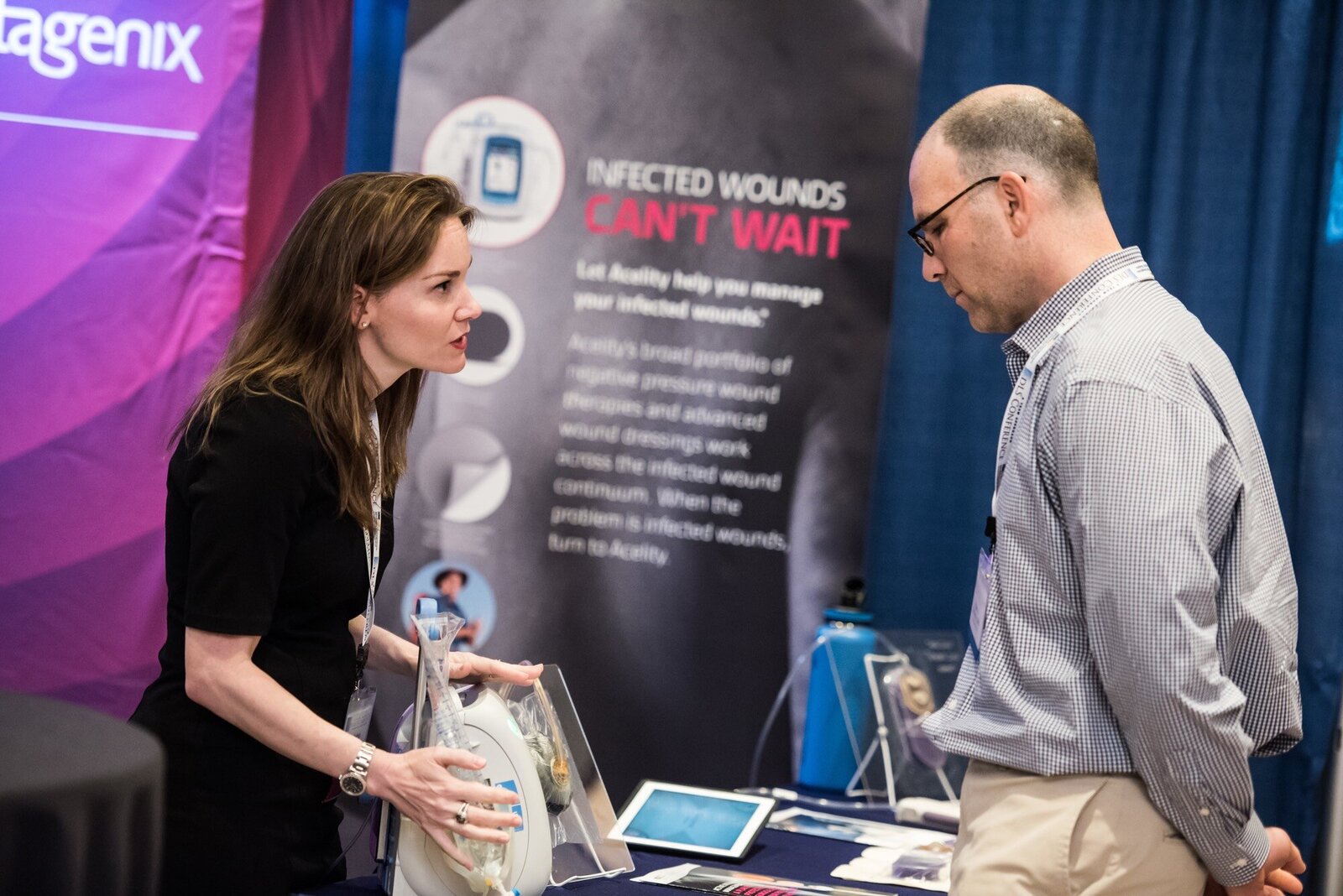 Company representative showing product to attendee of trade show