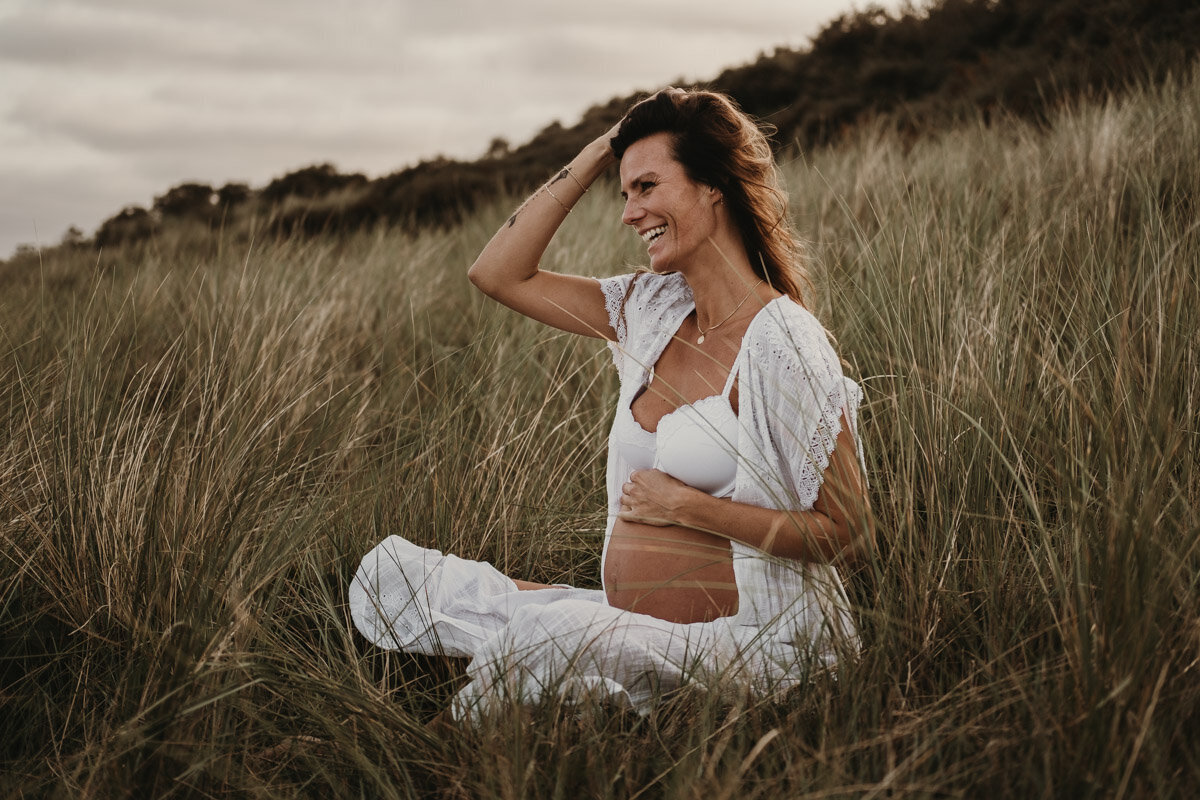 zwangere vrouw zittend in het gras