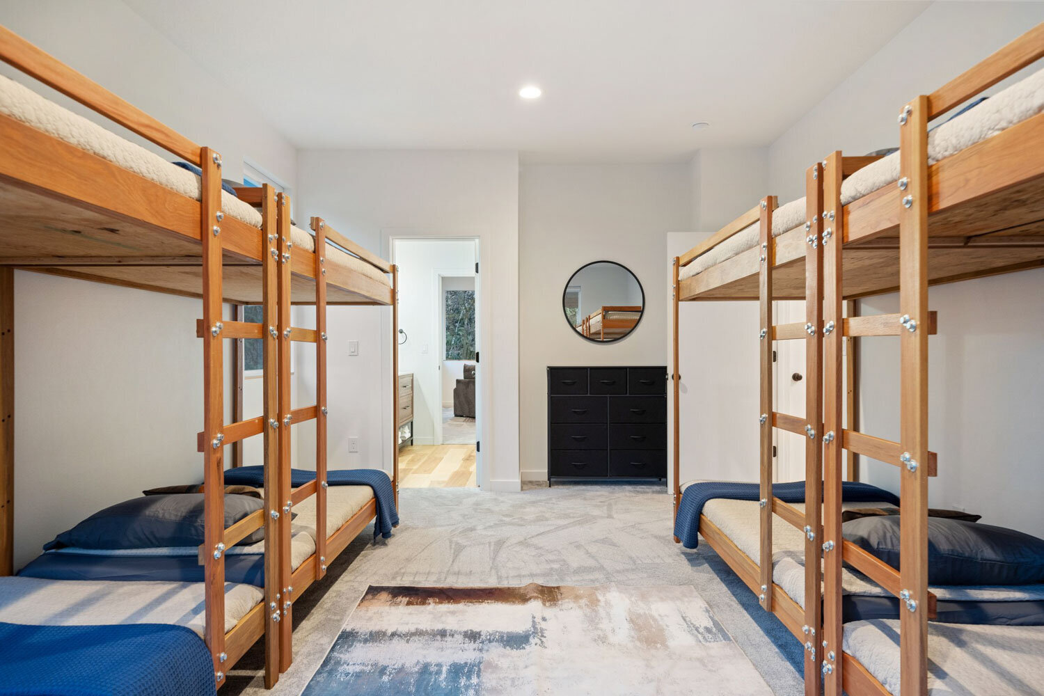 Bunk bed room with four wooden beds and navy bedding