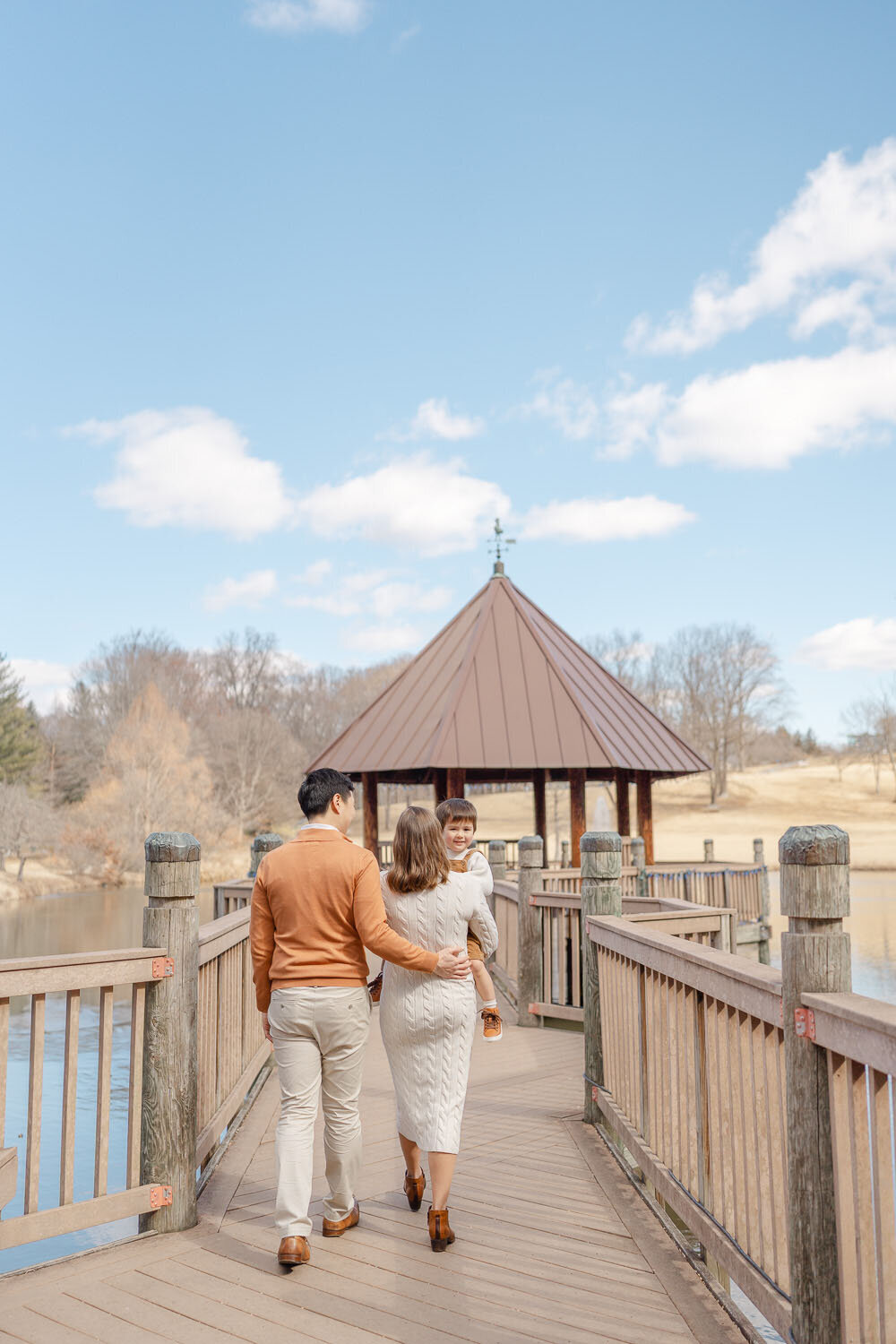 family of soon to be 4 walking in a gazebo