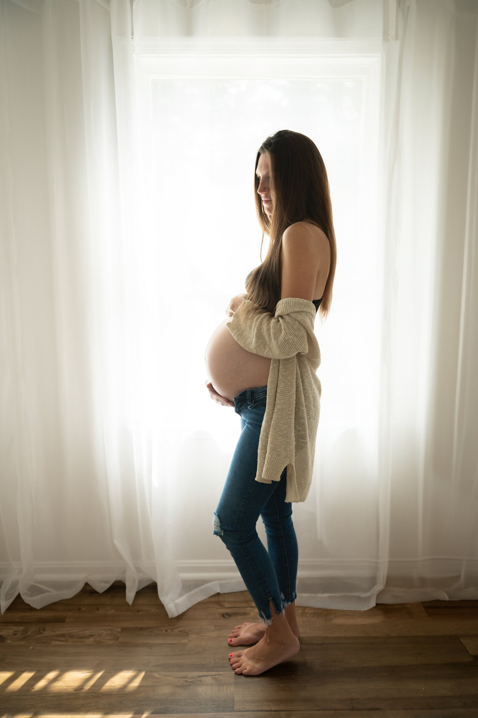 woman in her home looking at her belly