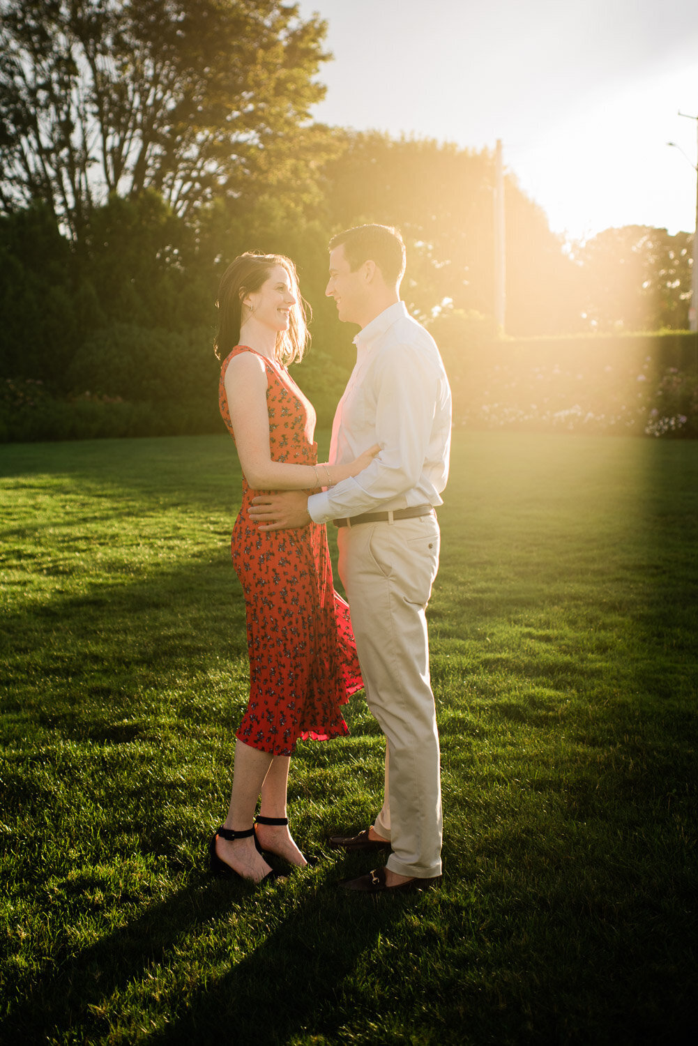 couple facing each other on lawn at golden hour