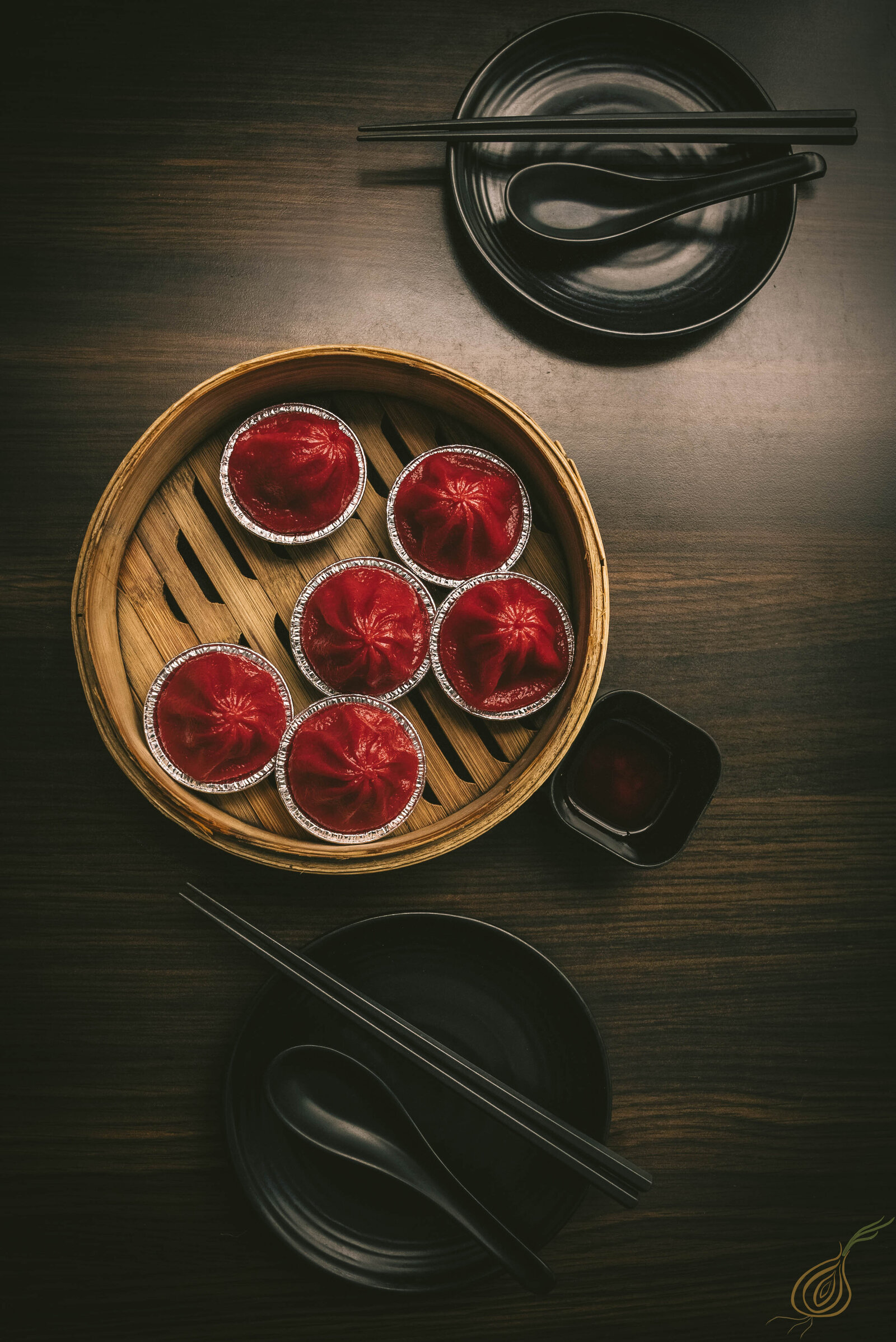 A table set with bowsl of various dumplings and traditional asian dishes and chopsticks, inviting a meal to be enjoyed.