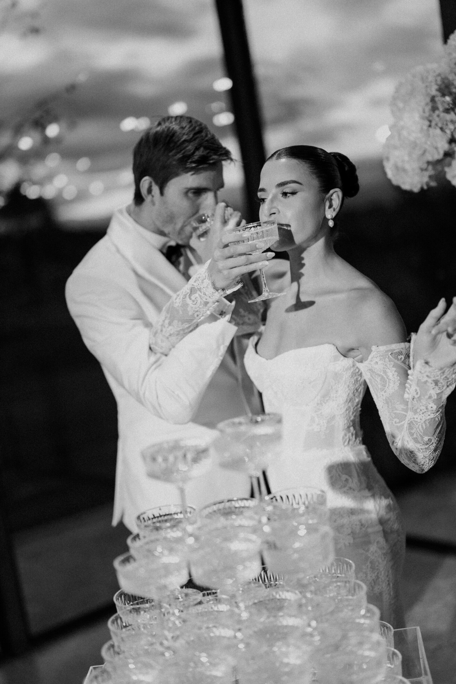 Bride and groom using champagne tower 