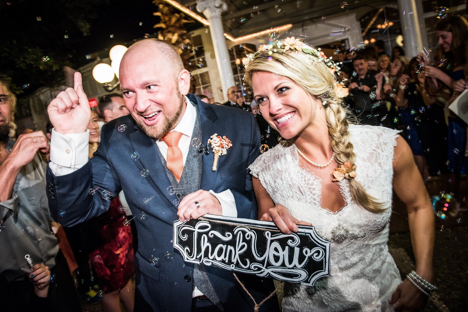 Couple walks out of Michabelle Inn Hammond wedding reception with a thank you sign