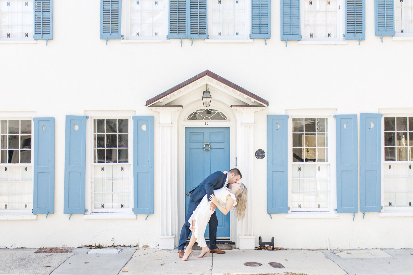 Couple share a kiss on sidewalk of Historic Downtown Charleston, South Carolina.