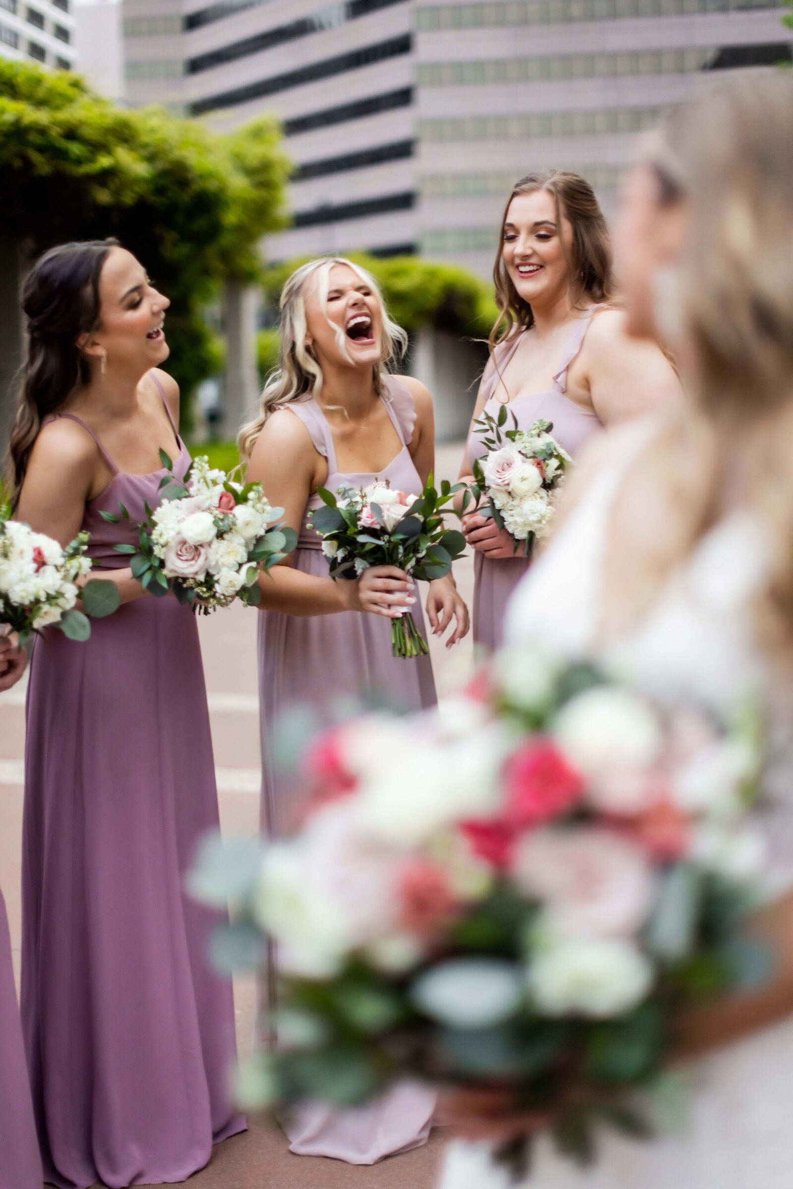 Witness the heartwarming camaraderie and support as this group of laughing bridesmaids surrounds the bride with both hype and grace. Captured in a moment of genuine happiness, this photograph showcases the essential role of bridesmaids in uplifting and celebrating the bride on her special day. Perfect for future brides looking for inspiration on creating a joyful and supportive bridal party atmosphere, this image highlights the power of friendship and laughter in making wedding day memories unforgettable.
