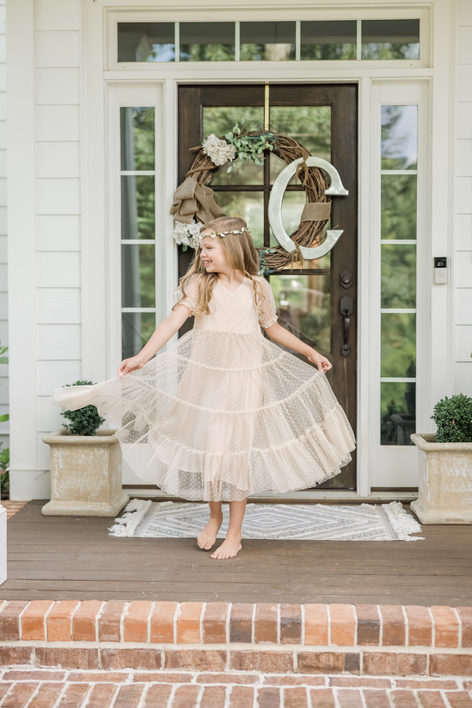 Girl twirling in dress on front porch.