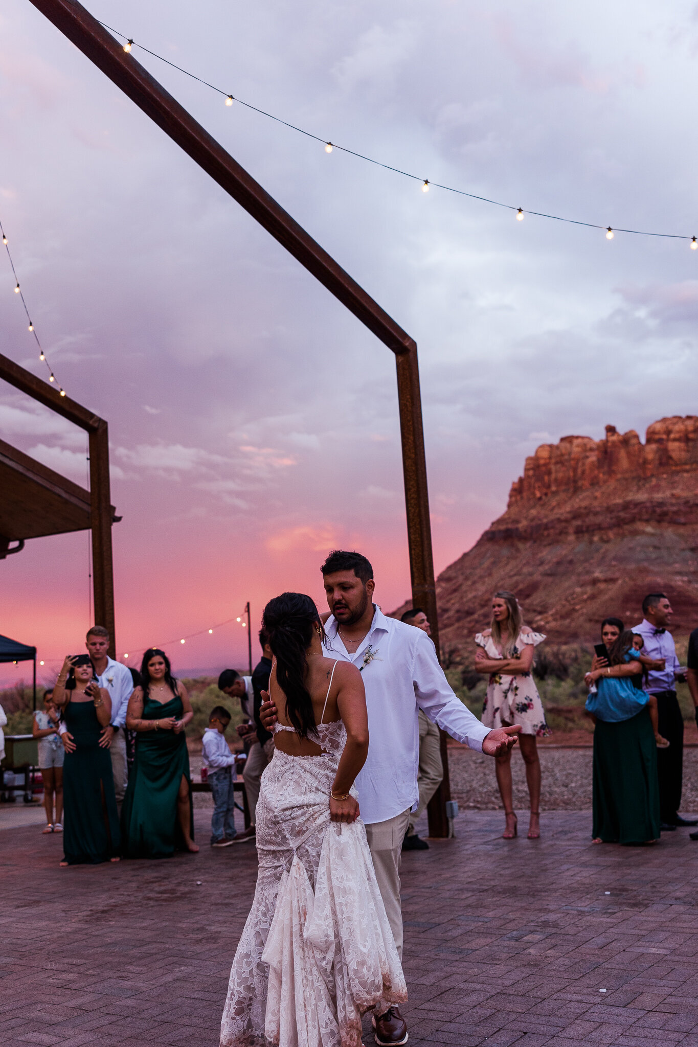 Bride and her brother dance under the pink sunset at the red earth venue