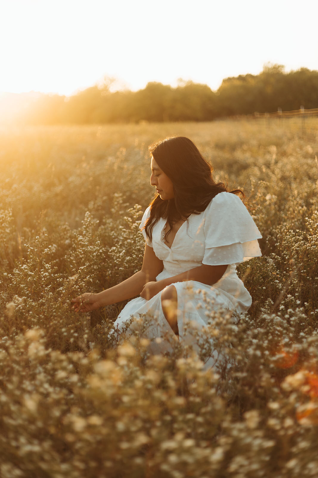 high school senior poses in a flower field for senior photos with ashley cole photography