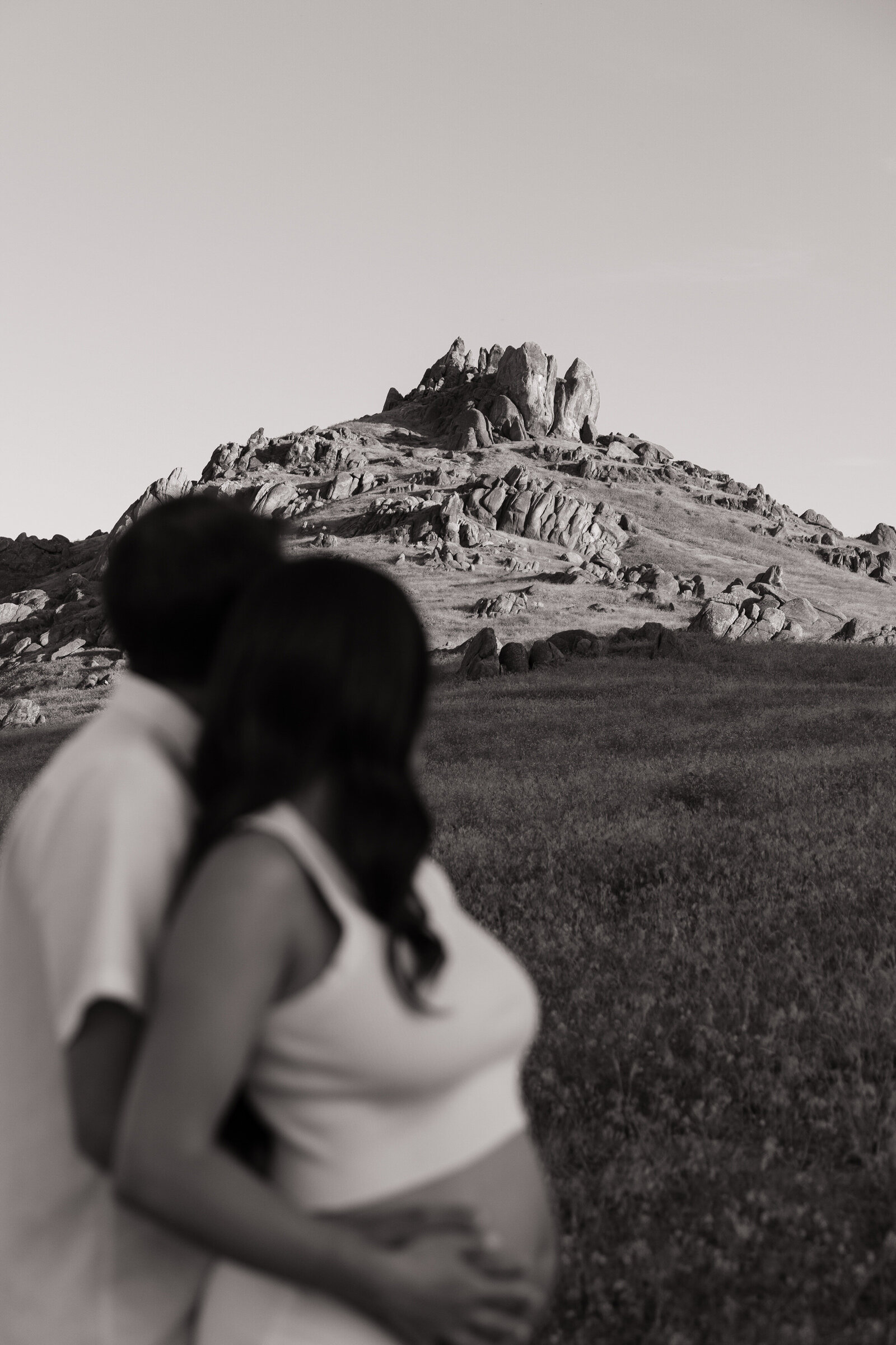 Expecting couple gazing out at majestic mountain backdrop