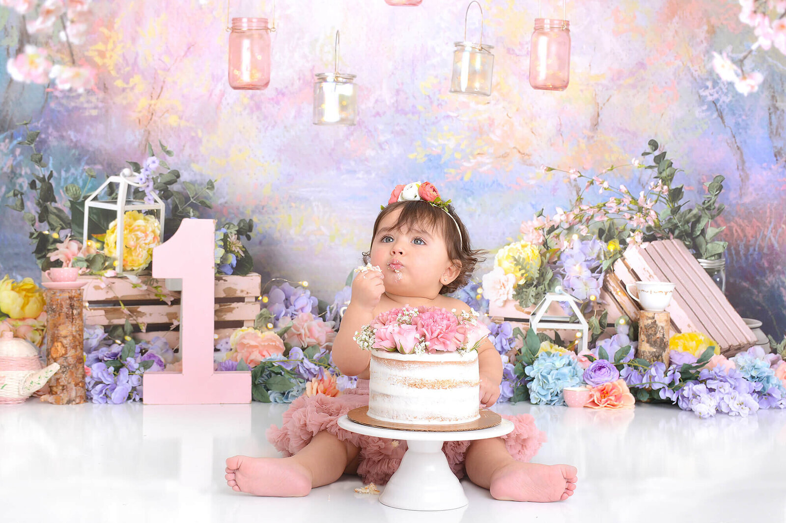 girl eats her birthday cake in front a beautiful floral background in houston