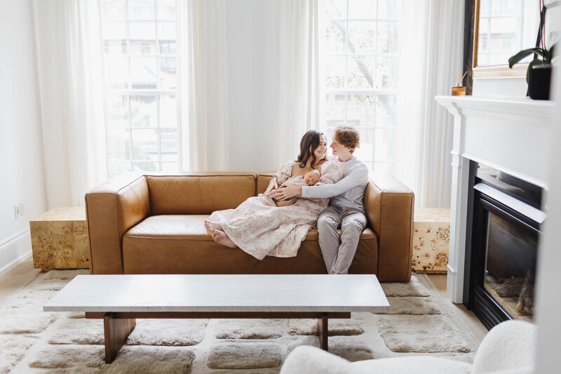 first time parents hanging out in their living room with their baby daughter.