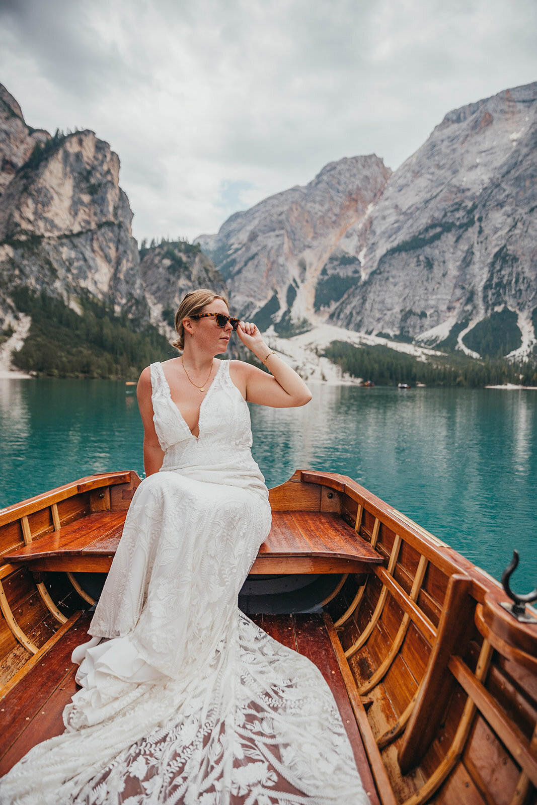 bride poses on boat in lake