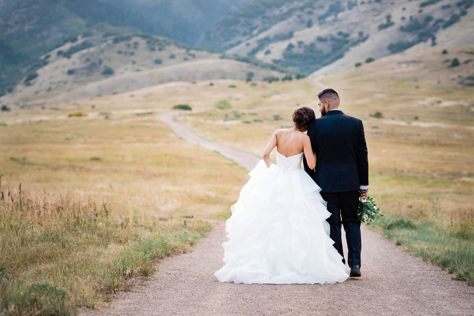 Bride and Groom walking together towards mountains