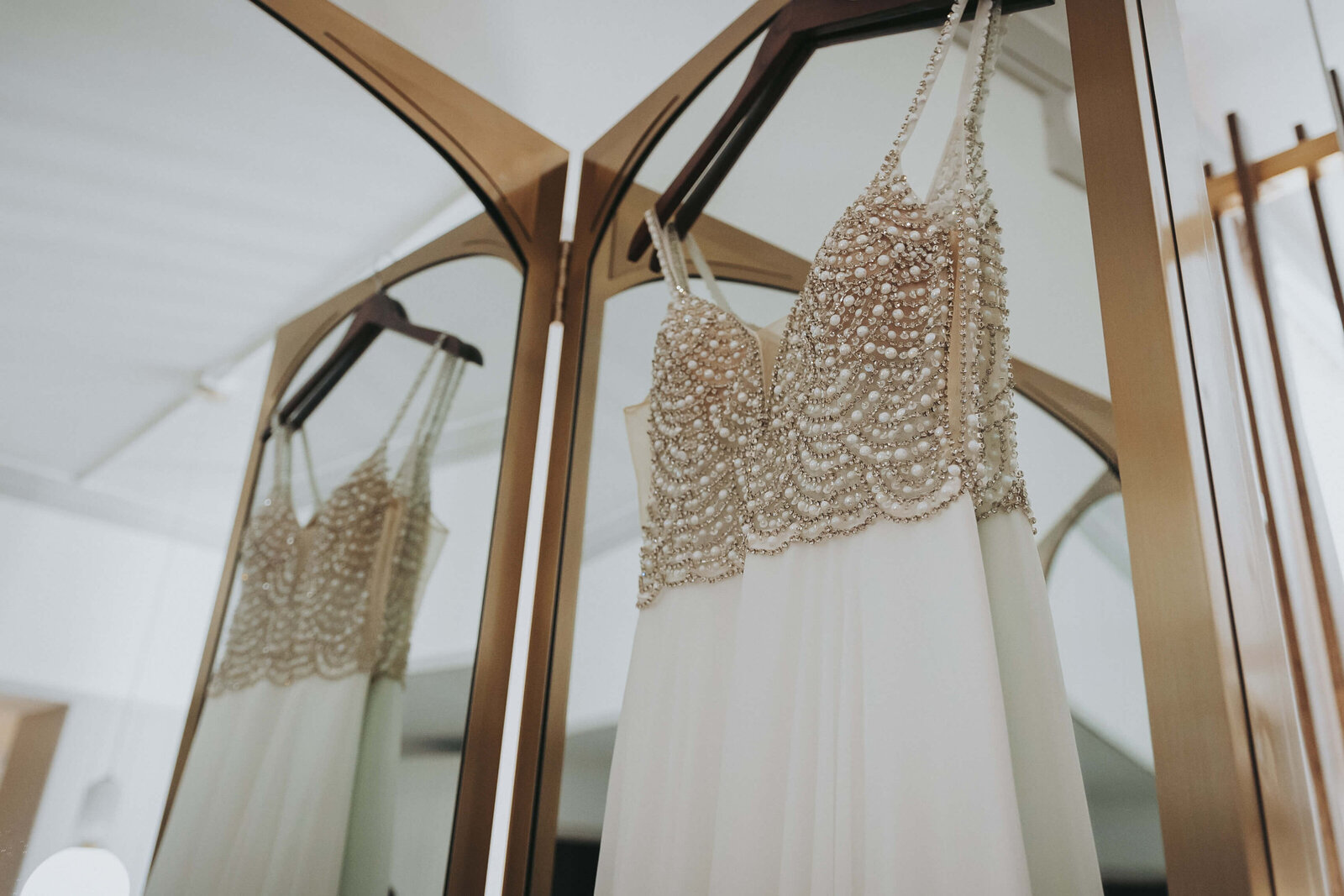 Gorgeous indie wedding dress hangs from the mirror