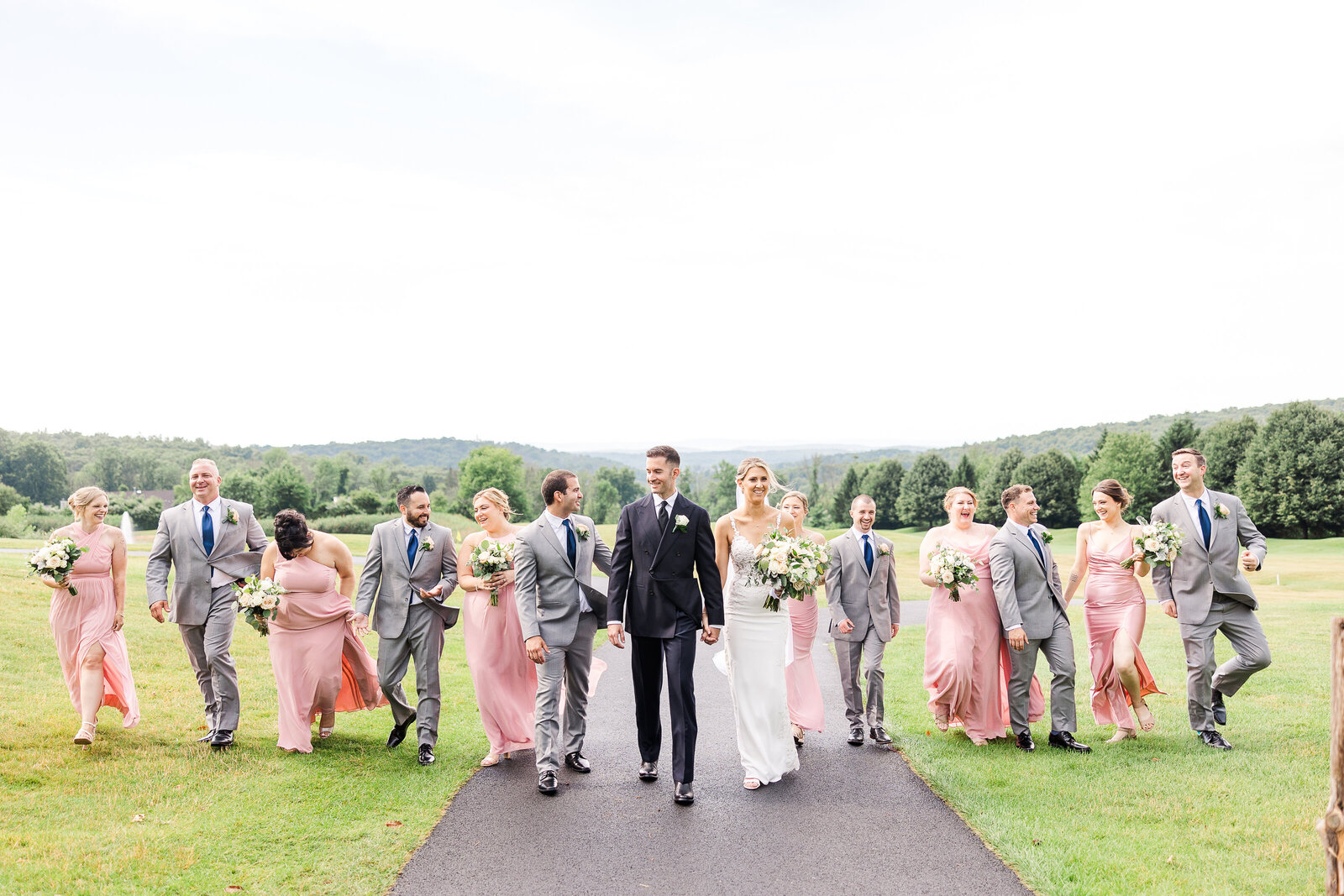  Entire wedding party walking and laughing during portraits at SkyView Golf Club