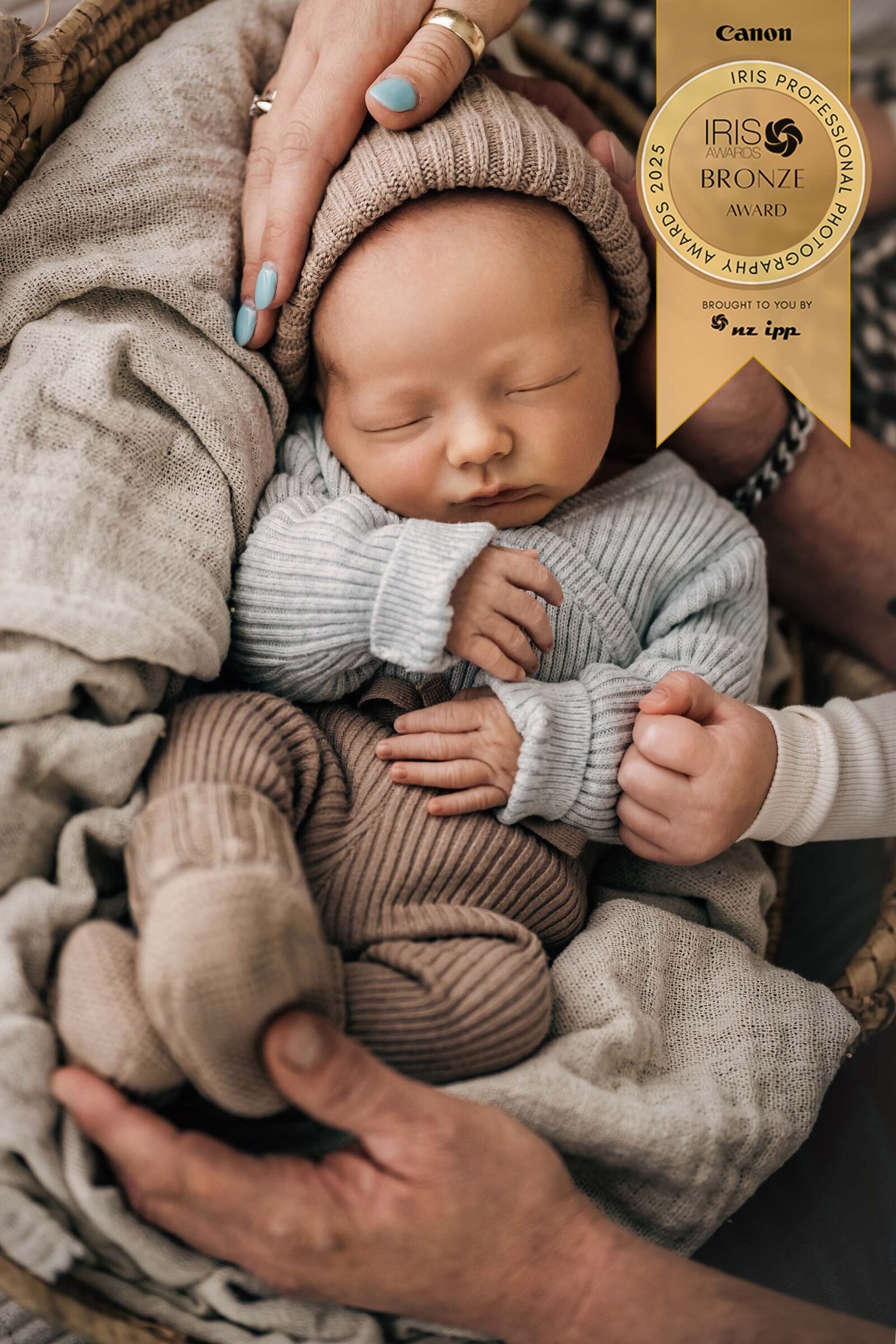 Bbay boy in neutral tones held by jis family 
