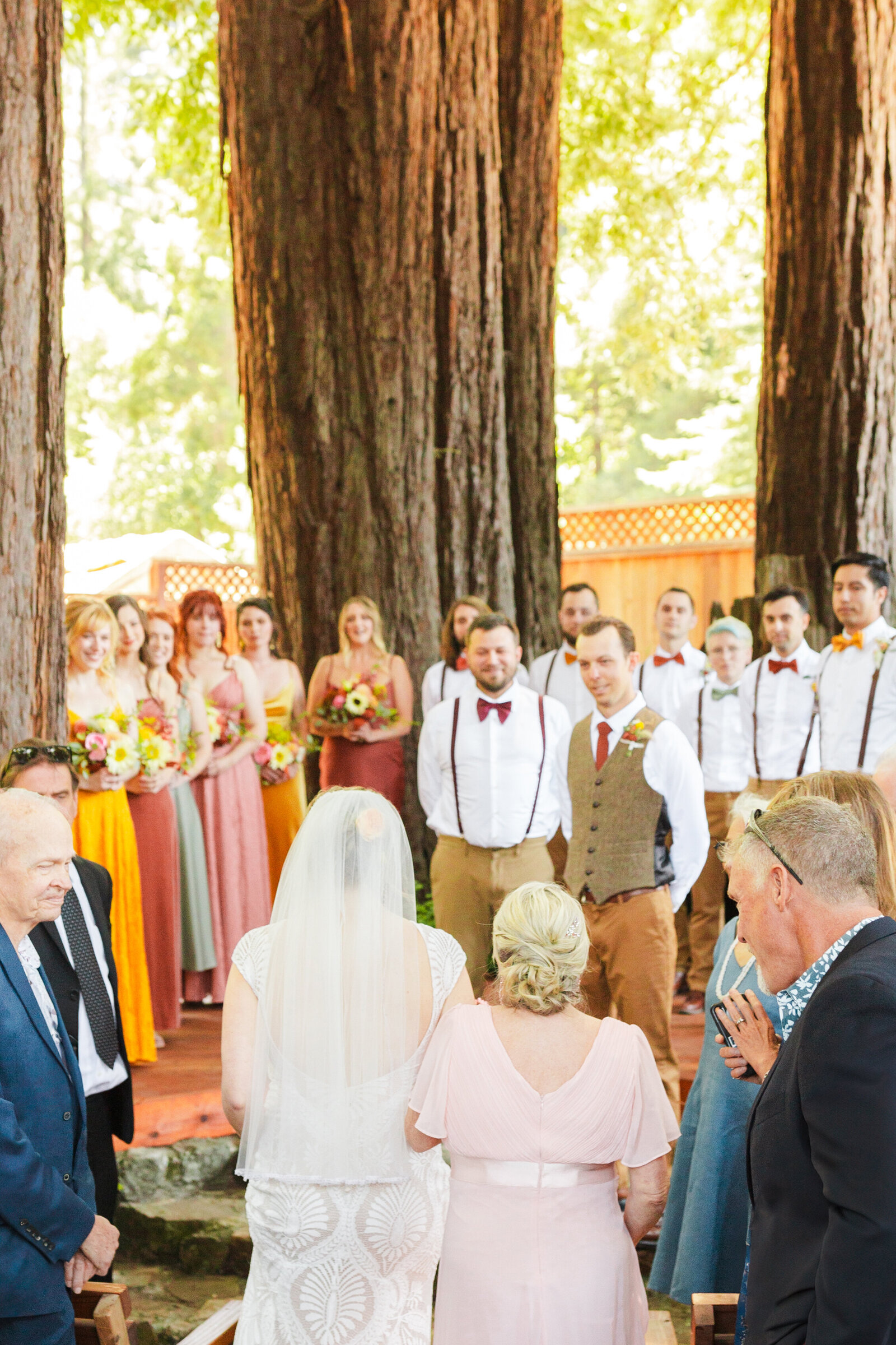Bride and groom at their colorful wedding ceremony in Santa Cruz, California in the redwood trees.
