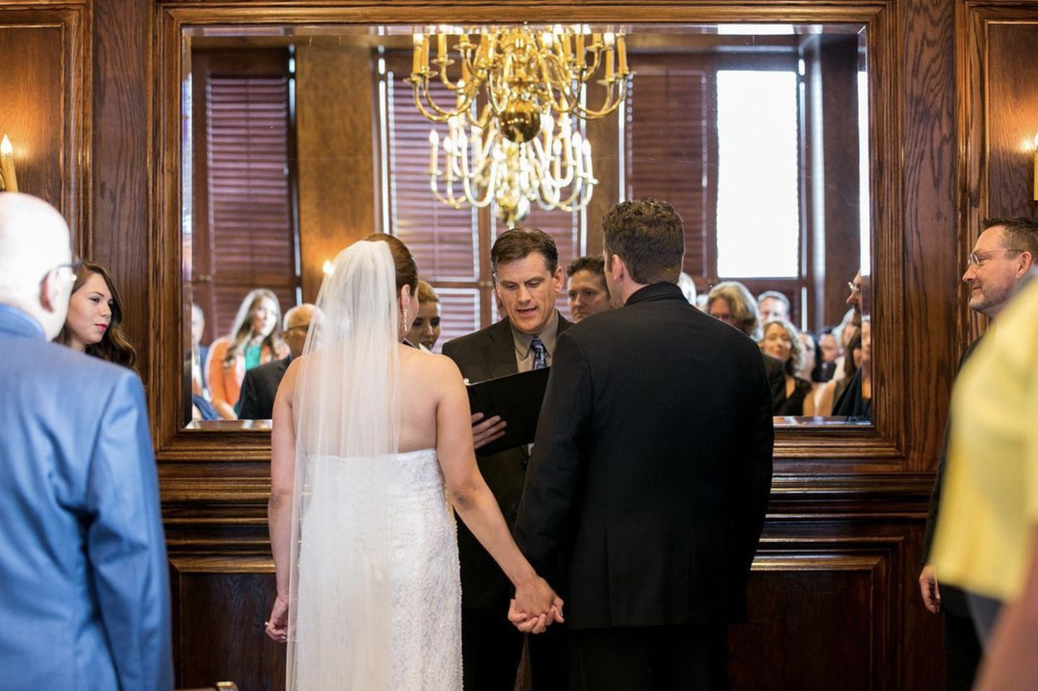 Bride and groom hold hands during wedding ceremony