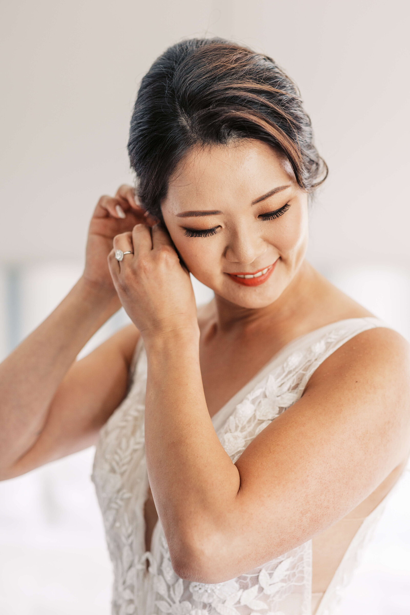 Bride puts on her diamond earrings.