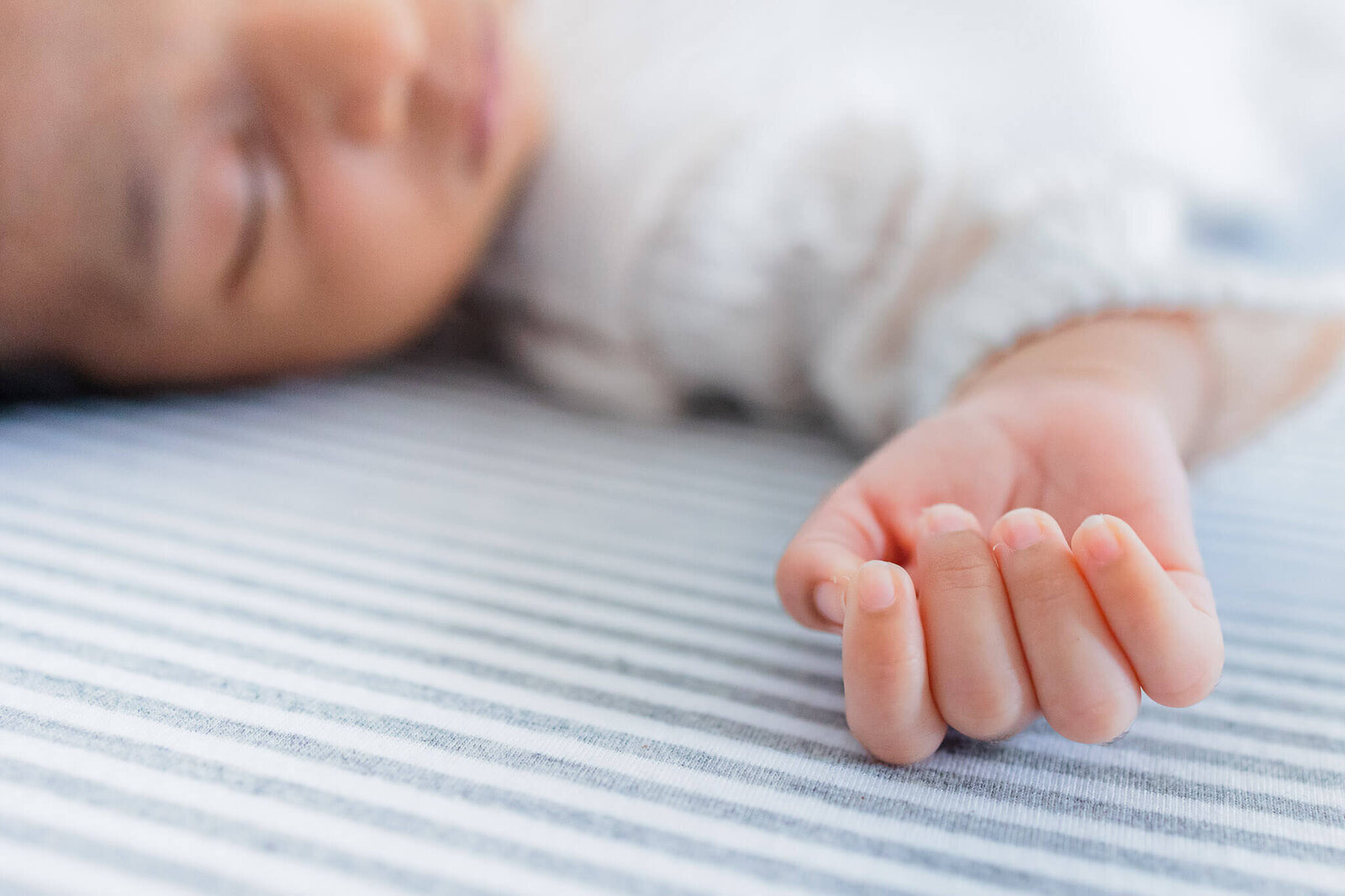 A close-up of a newborn baby boy's hand.