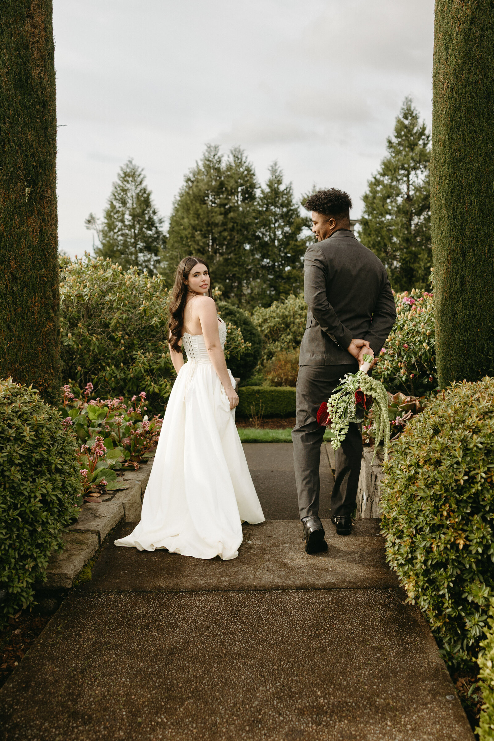 A bride and groom frolic around a beautiful garden at a chateau in Vancouver. 