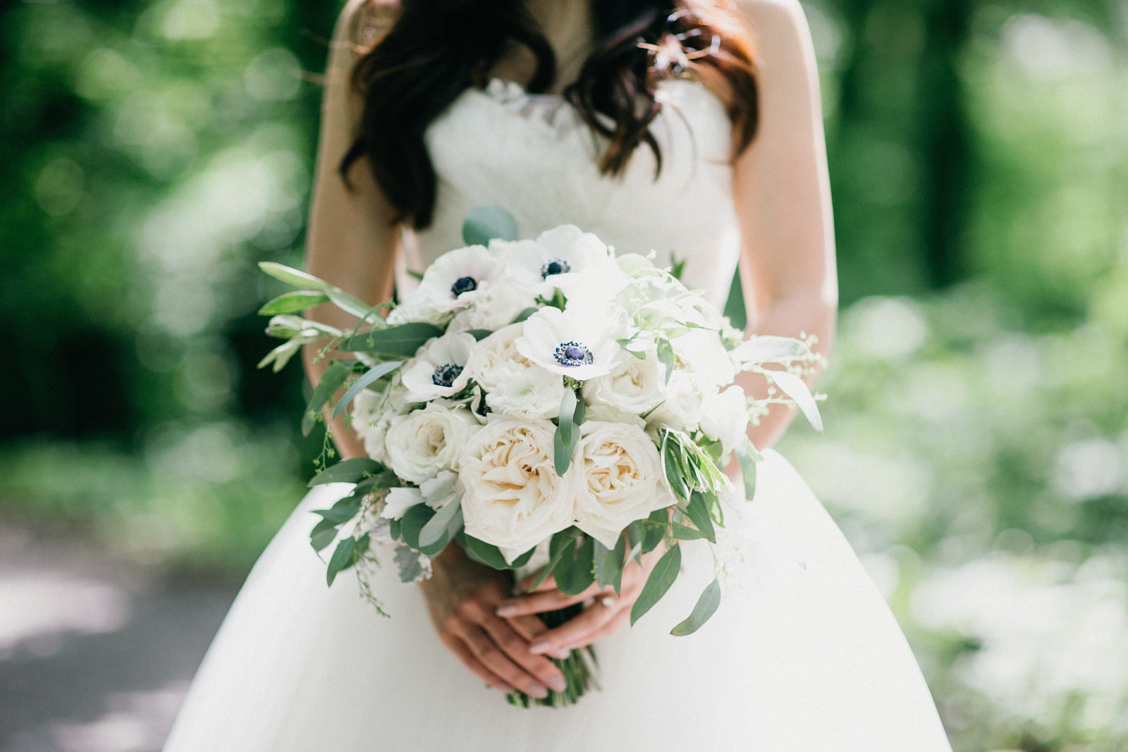 Bride holding a gorgeous bouquet of white florals at this woodsy New Jersey wedding venue.