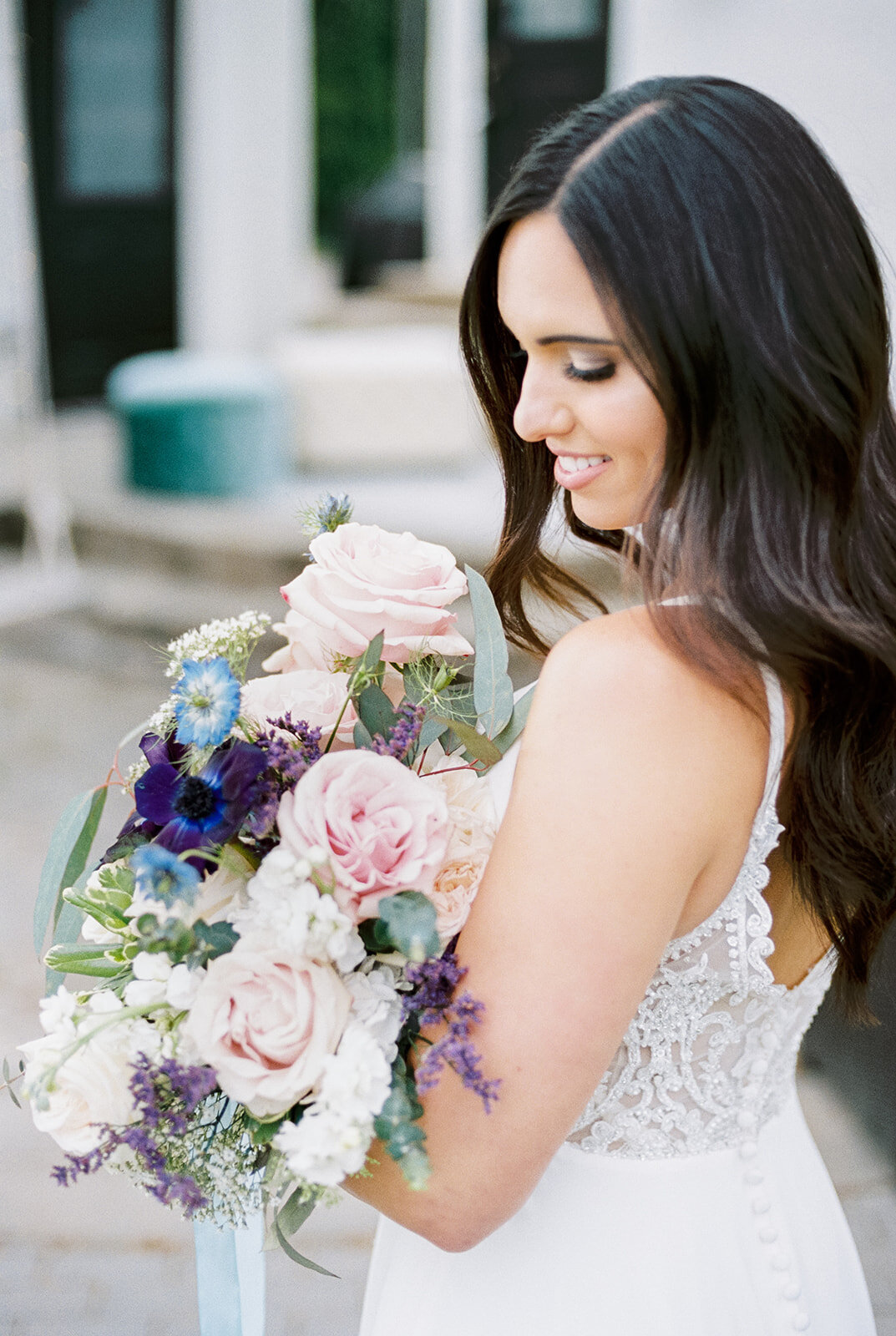 Bride holding blue, blush, and purple wedding flower bouquet at Cottage at Riverbend Wedding by the Best Boise Wedding Photographers