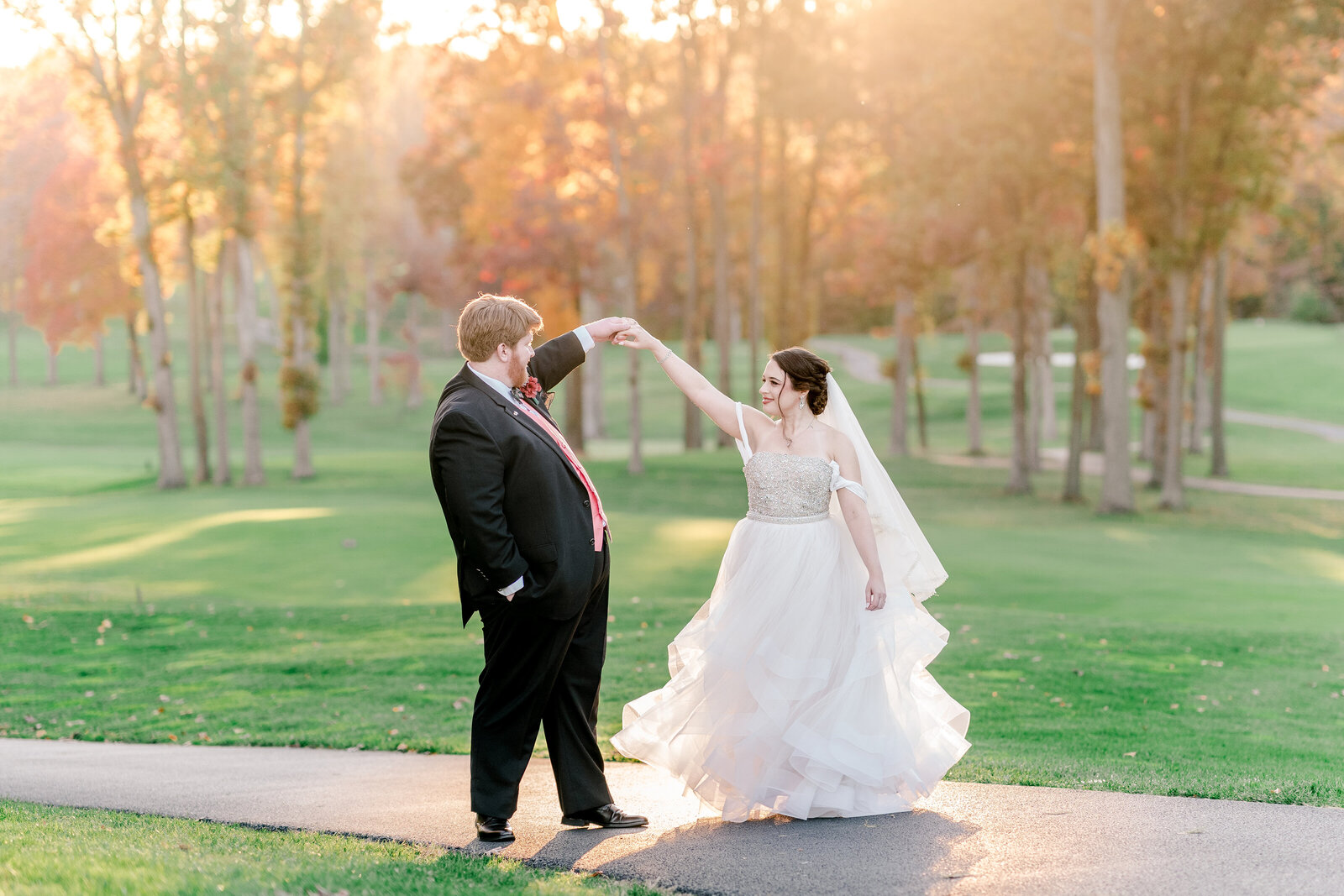 A groom twirling his bride in golden hour light during a fall wedding in Northern Virginia