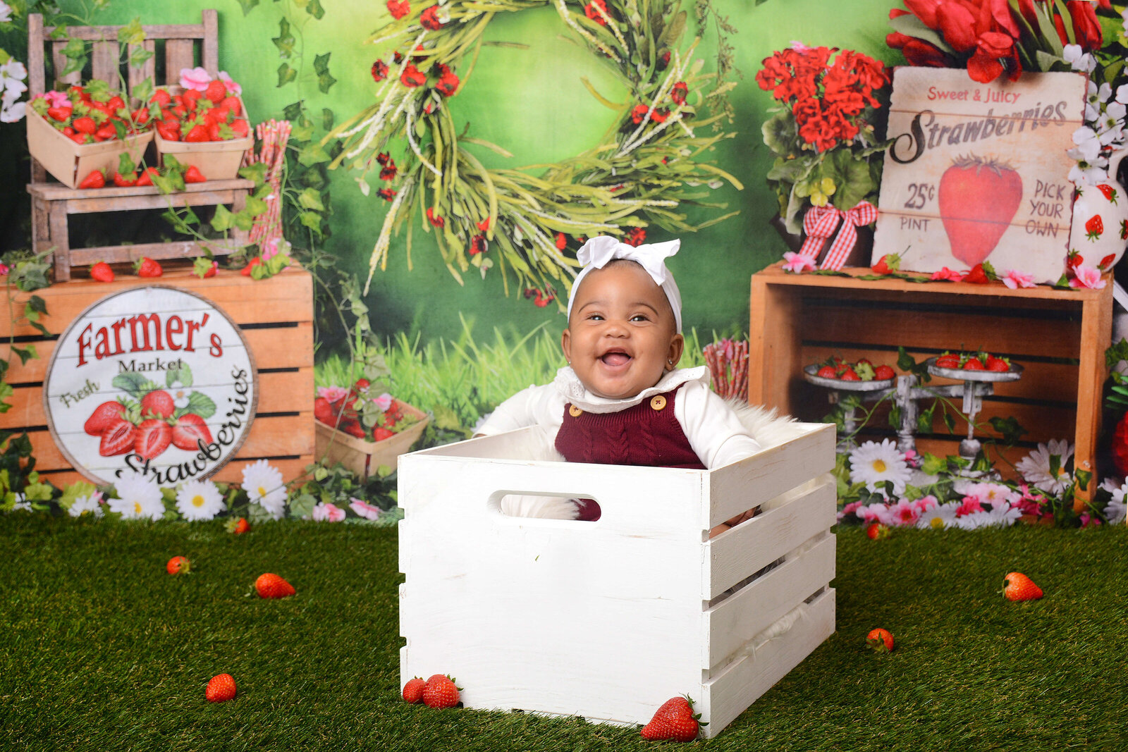 girl smiles at strawberry themed half birthday photoshoot
