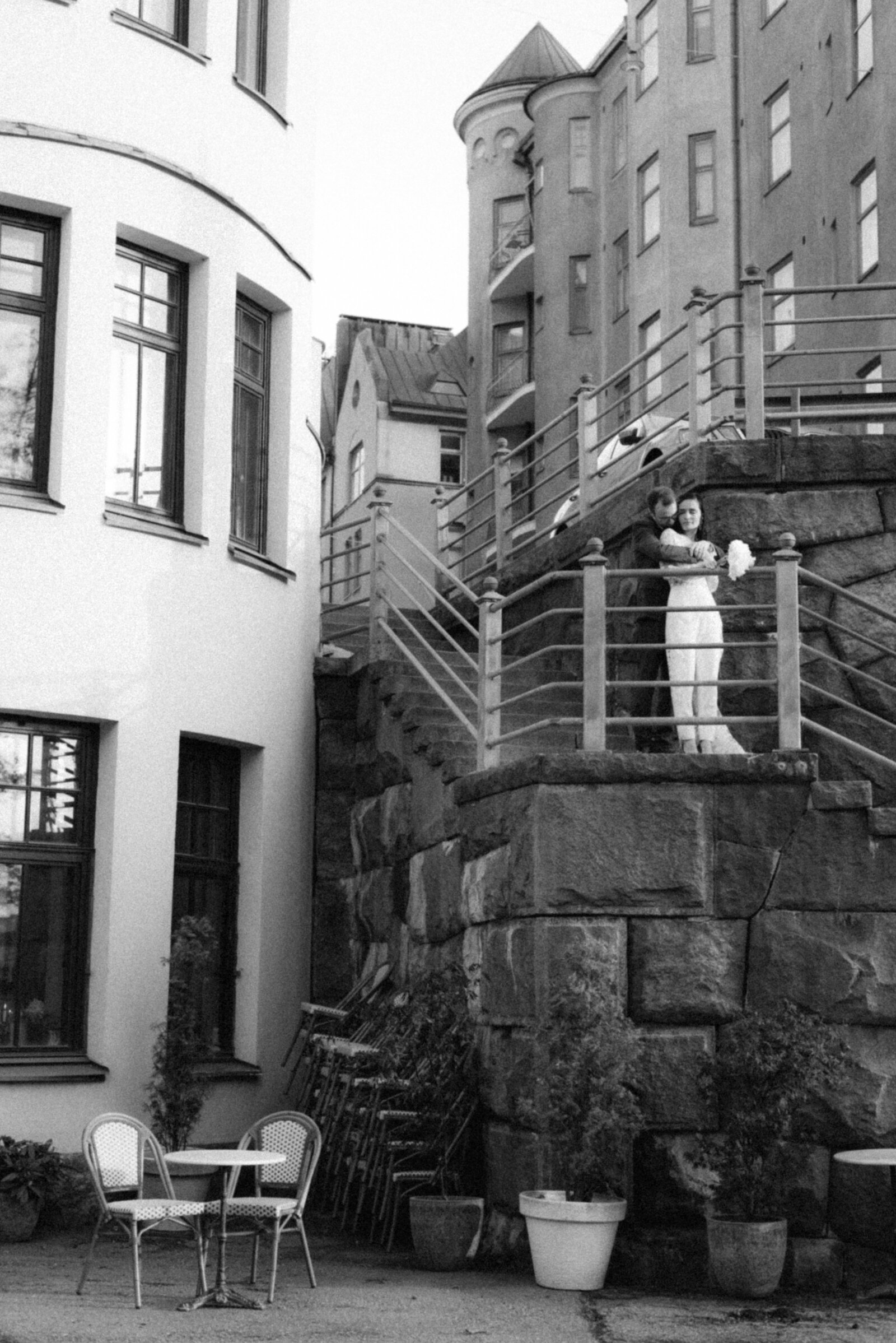 A urban image from the street in Helsinki. A wedding couple is standing on the stairs during their wedding photography by a Finnish wedding photographer Hannika Gabrielsson.