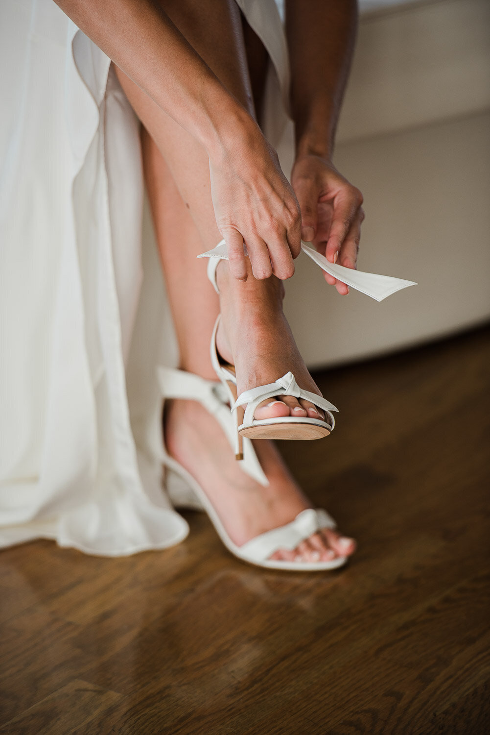 closeup of bride heels with ribbon being tied