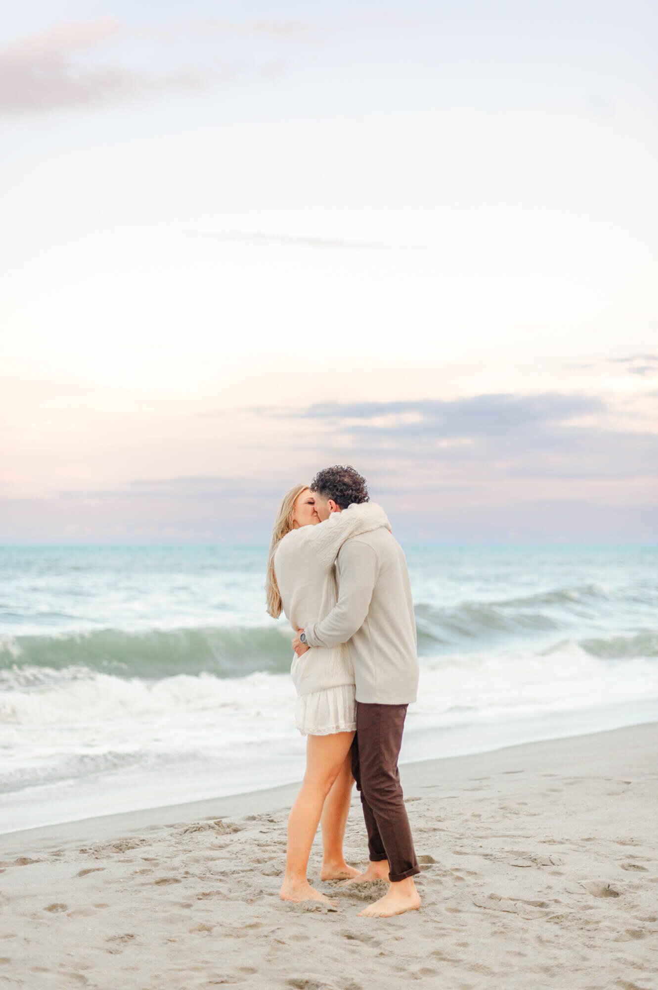 Couple hugging and kissing during their Orlando oouples beach photoshoot