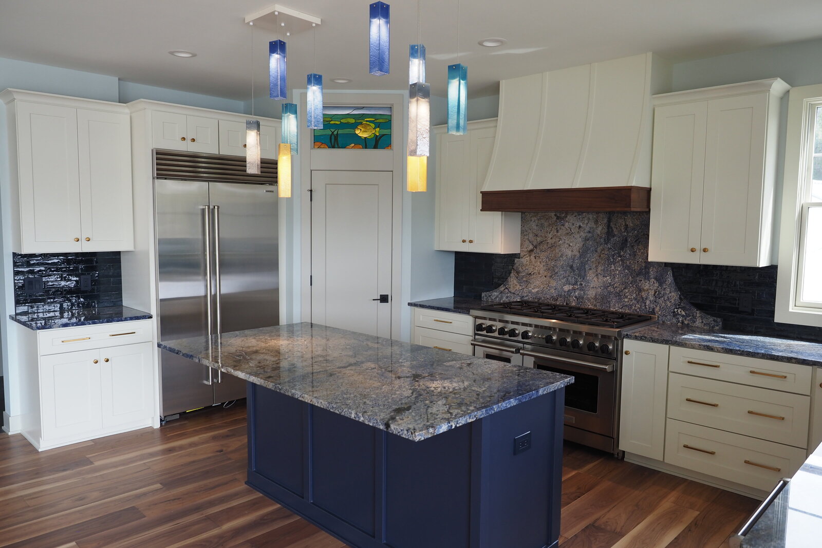 View of a kitchen with off white and navy blue cabientry.