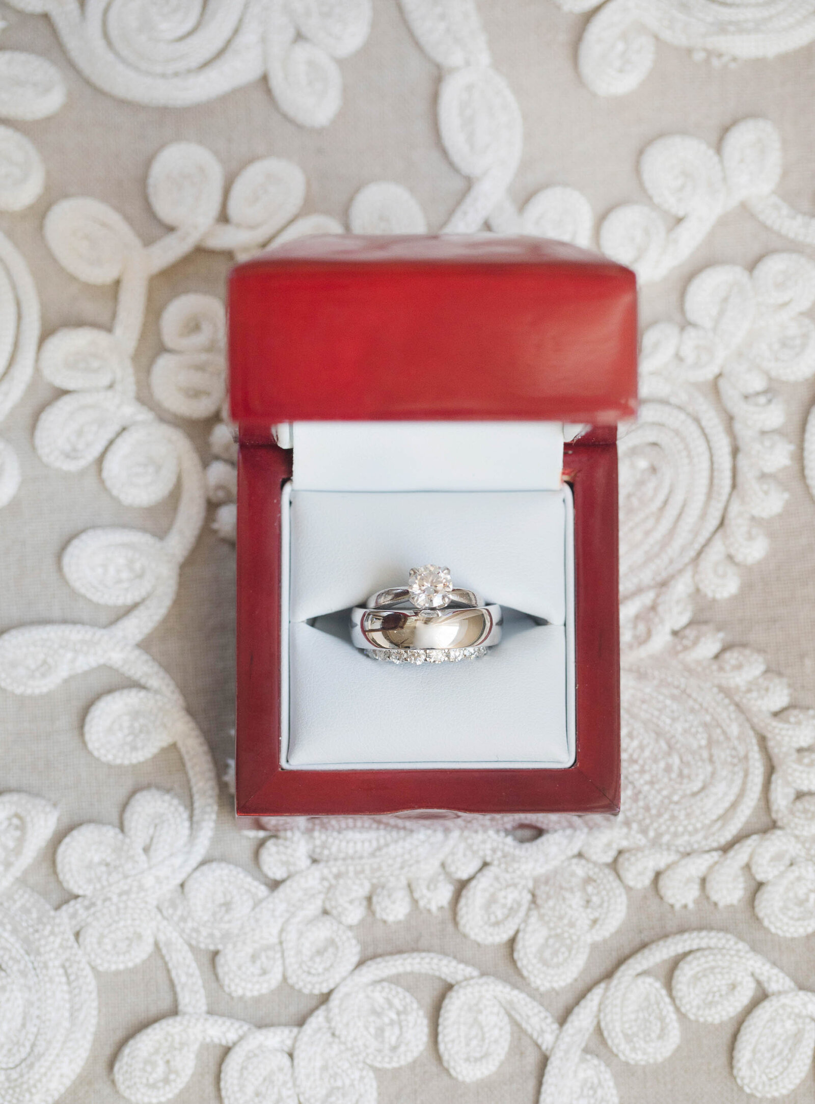 Detailed shot of bride and groom wedding rings in a ring box on lace covered table. Private Estate Wedding New Hope Pennsylvania 