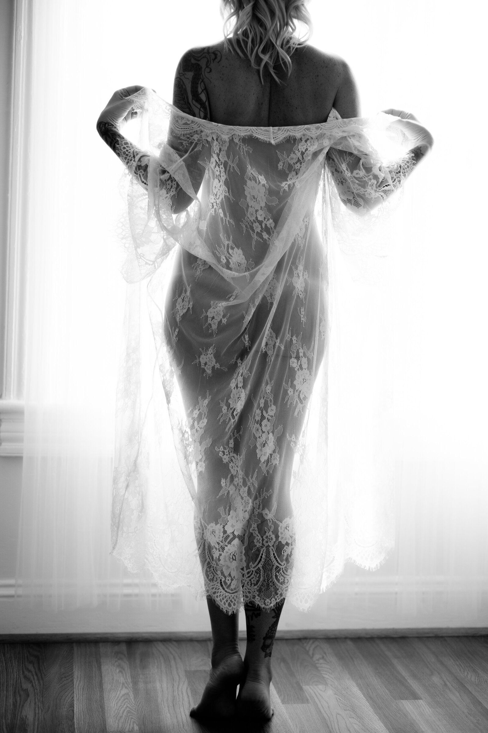 Black and white boudoir photo of woman wearing lacylingerie