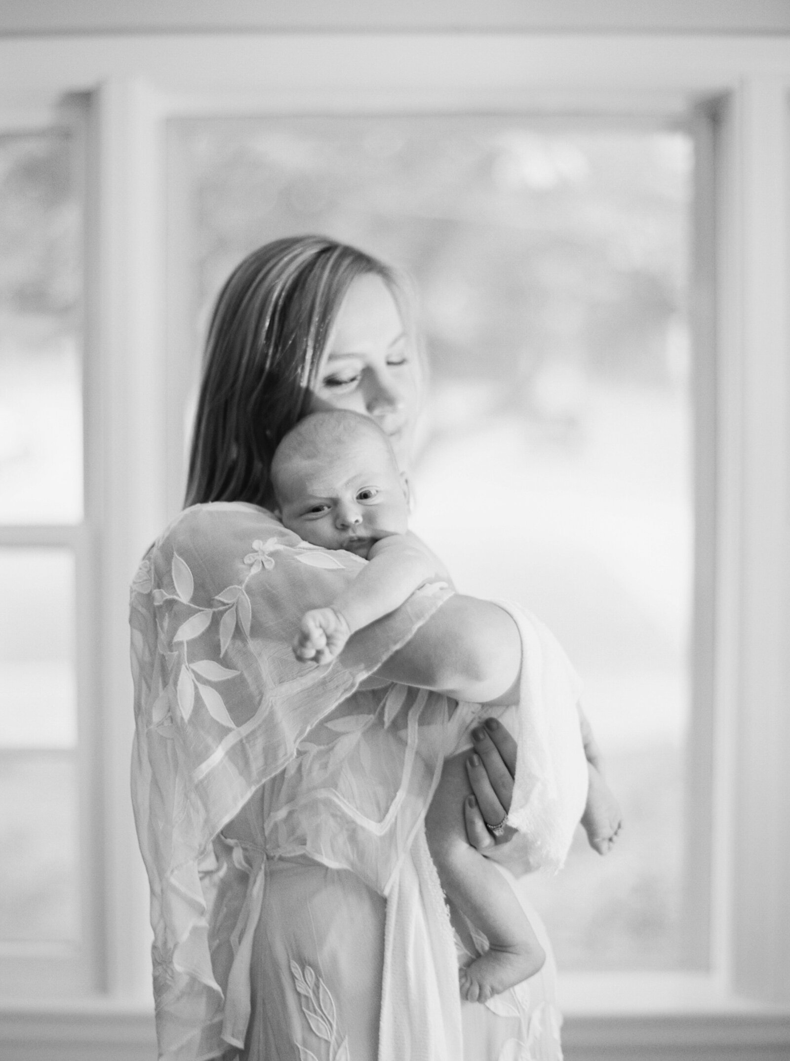 Mom holding newborn in family photography