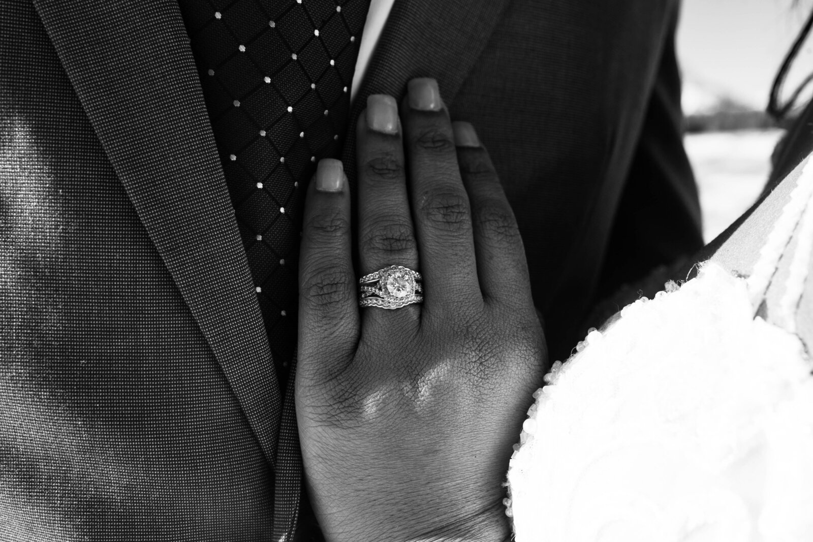 detail shot of brides wedding ring as she holding her hand to her grooms suit captured by Idaho Falls wedding photographer