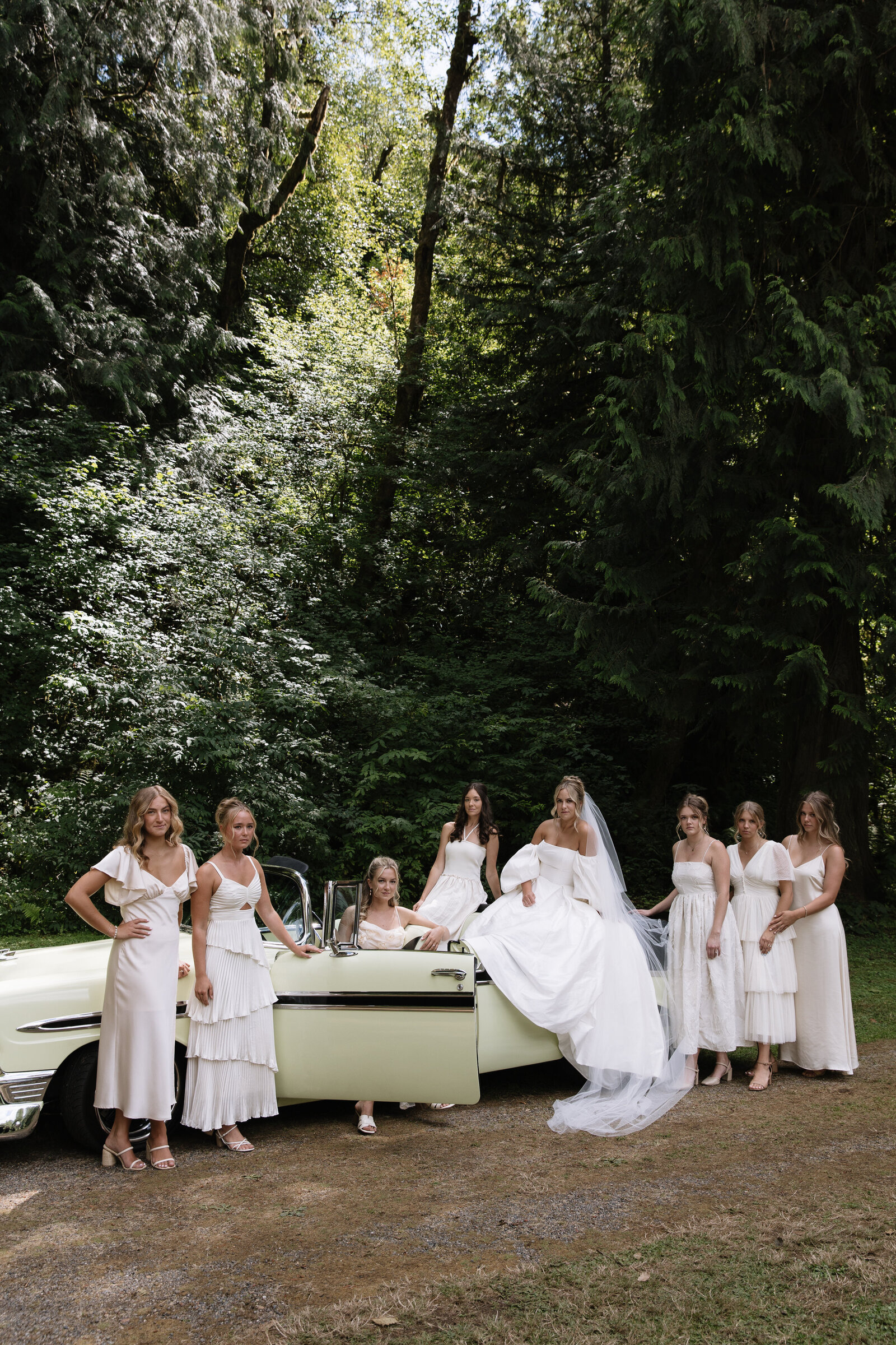 Bride and bridesmaids pose alongside classic car for group photos at intimate Washington wedding
