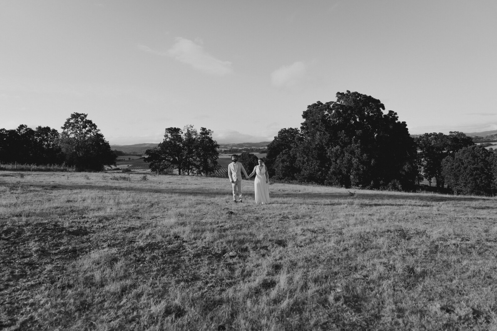 Bride and groom stand in an open field